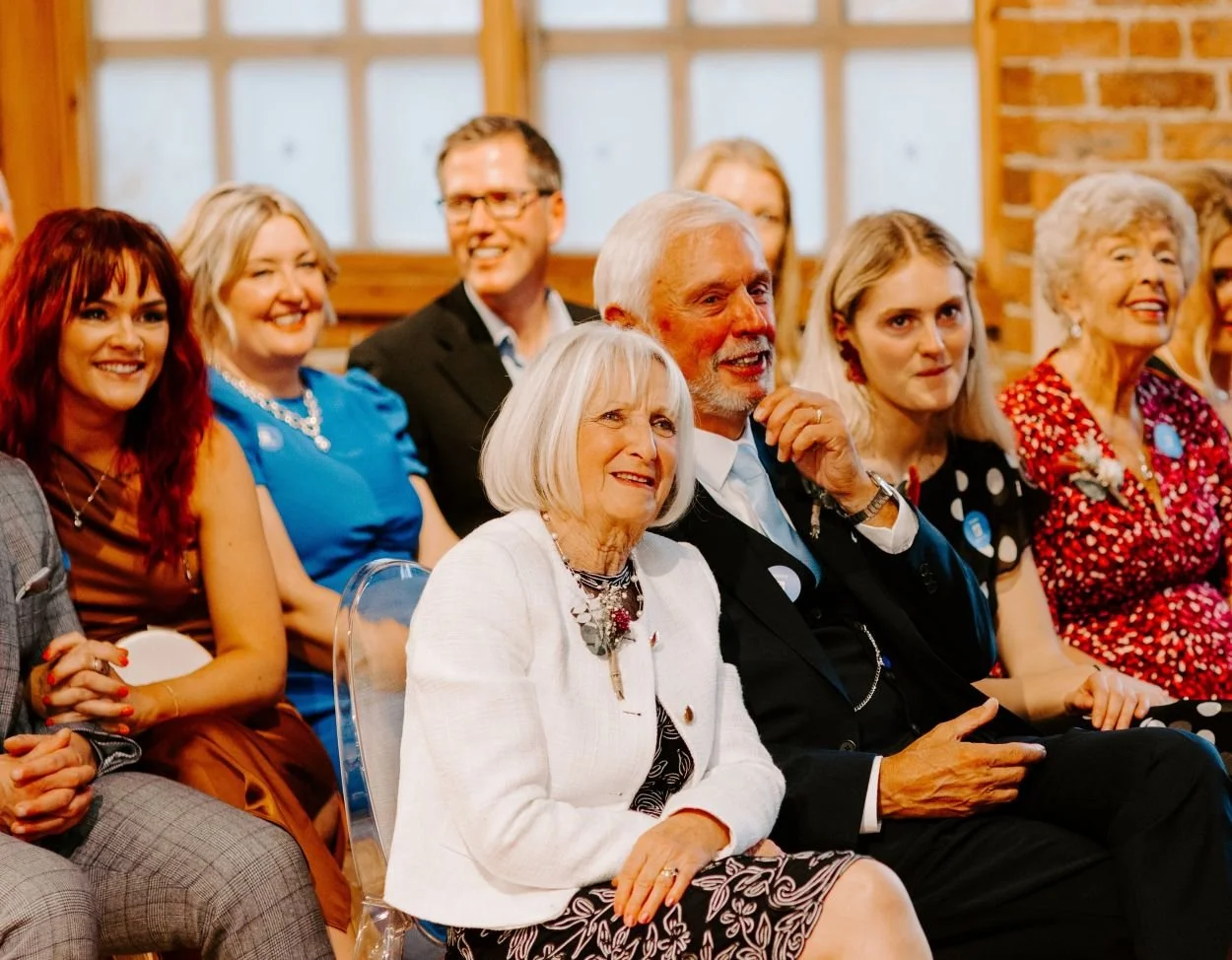 The front two rows of Newcastle wedding ceremony guests look towards Kate, the wedding celebrant (who is out of shot)