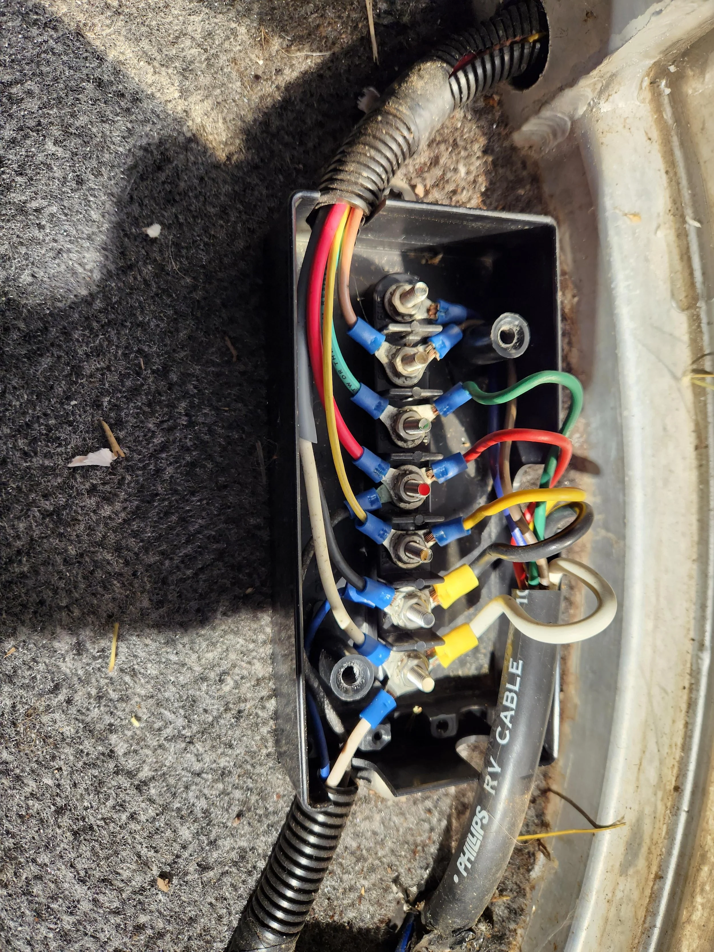 Car engine with three alligator clip battery jumpers attached to the battery terminals.