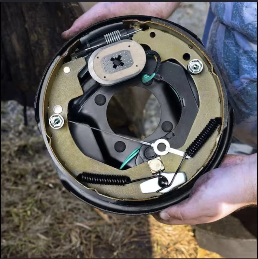 Close-up of a car's disc brake assembly, including the brake caliper, rotor, and wheel hub.