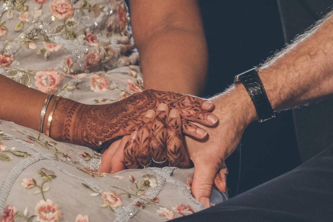 Bride Holding Groom’s Hand – Displaying Mature Bridal Henna Stain