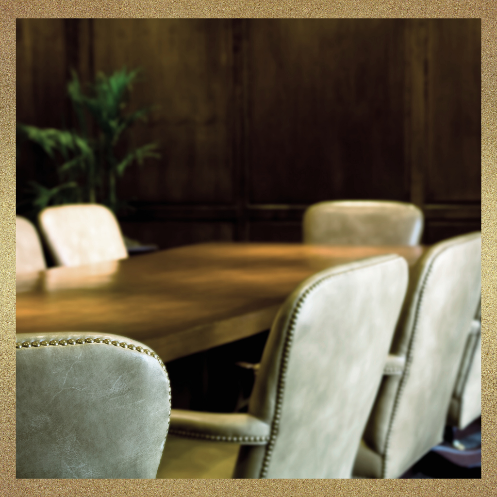 Executive meeting table with leather chairs in a quiet conference room, symbolizing leadership dynamics and reading the room before discussion begins.