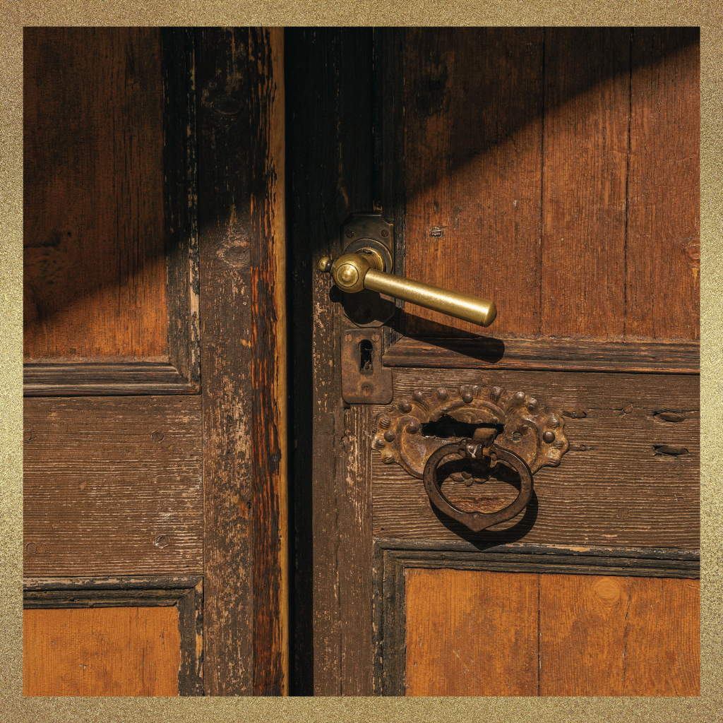 Close-up of an antique wooden door with a brass handle, symbolizing preparation before stepping into a new physician leadership role.