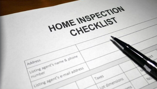 Professional home inspector reviewing a detailed inspection checklist for pricing in a Twin Cities, MN home.