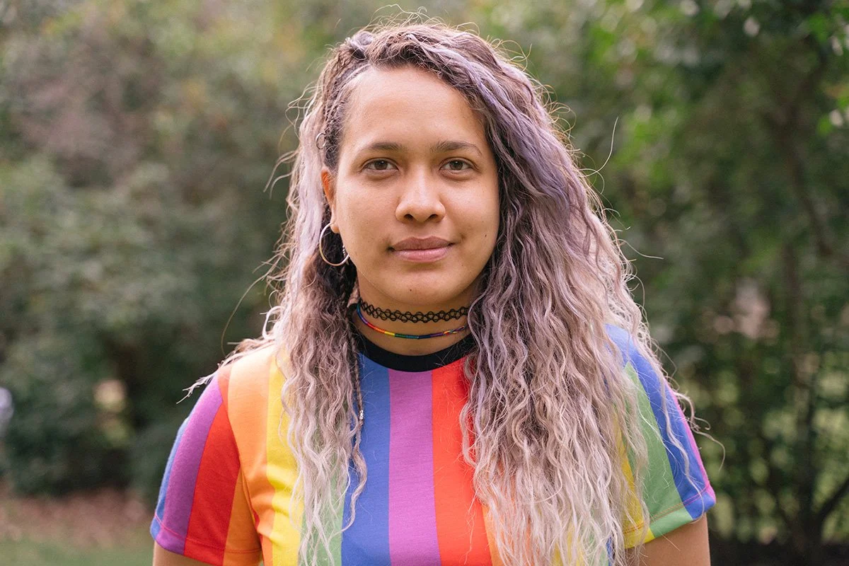 Group of diverse people smiling and posing together outdoors in a park.