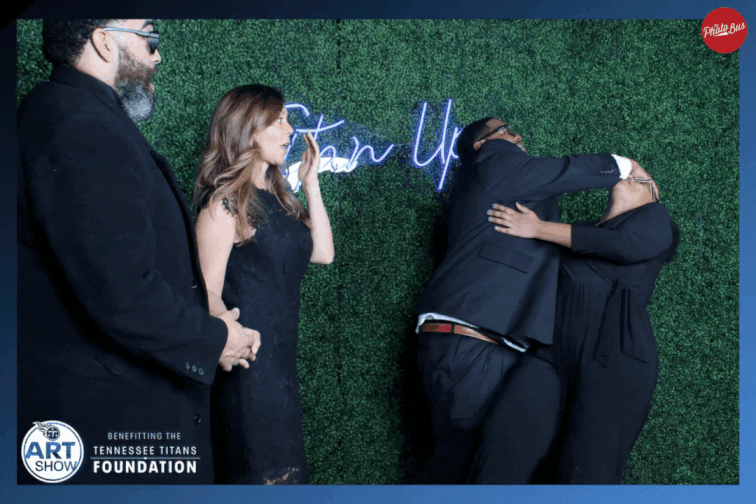 Four people at an event in a funny pose for an array photo booth. Two people are pretend fighting and the other two are pretending to be shocked. The final result is a 3D moving image.