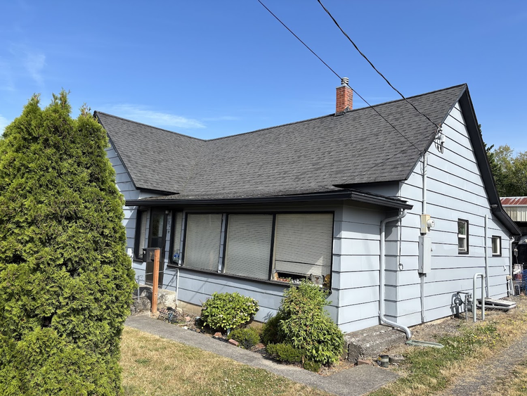 White home with a new dark shingle roof by Topside