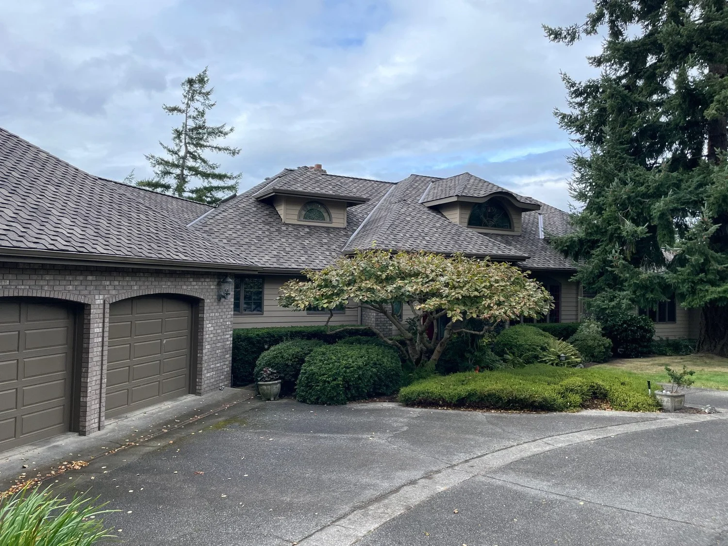 Brown shingle roof on a craftsman home with stone accents