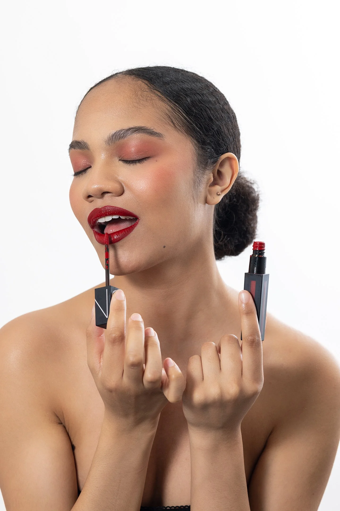 A bold studio photoshoot in New York City highlighting a beauty brand’s signature red lipstick. Featuring a clean, modern look with striking pops of color, the model’s confident expression and flawless finish capture the timeless allure of red lips.