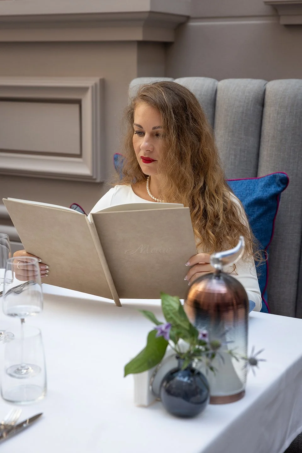 A woman sitting in a restaurant, looking at th menu