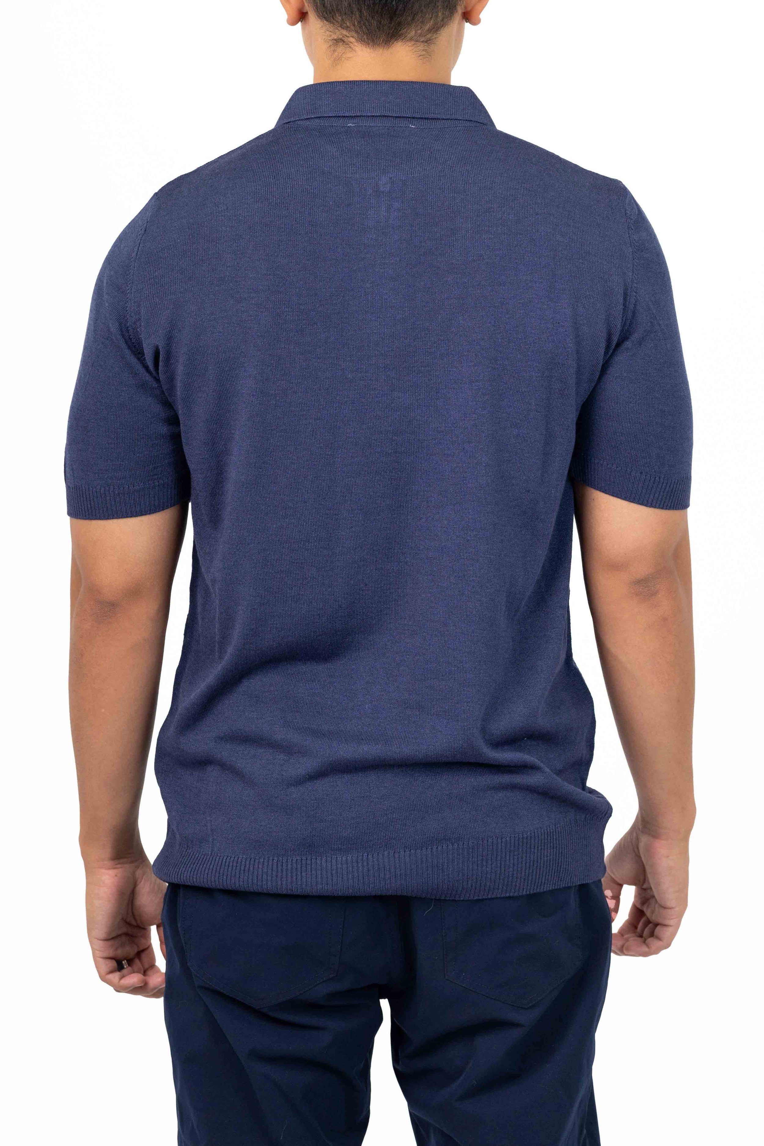 Man wearing a dark blue short-sleeve polo shirt and navy pants, shown from the back. Catalogue Photography. Photographed by Anna Meshcheri