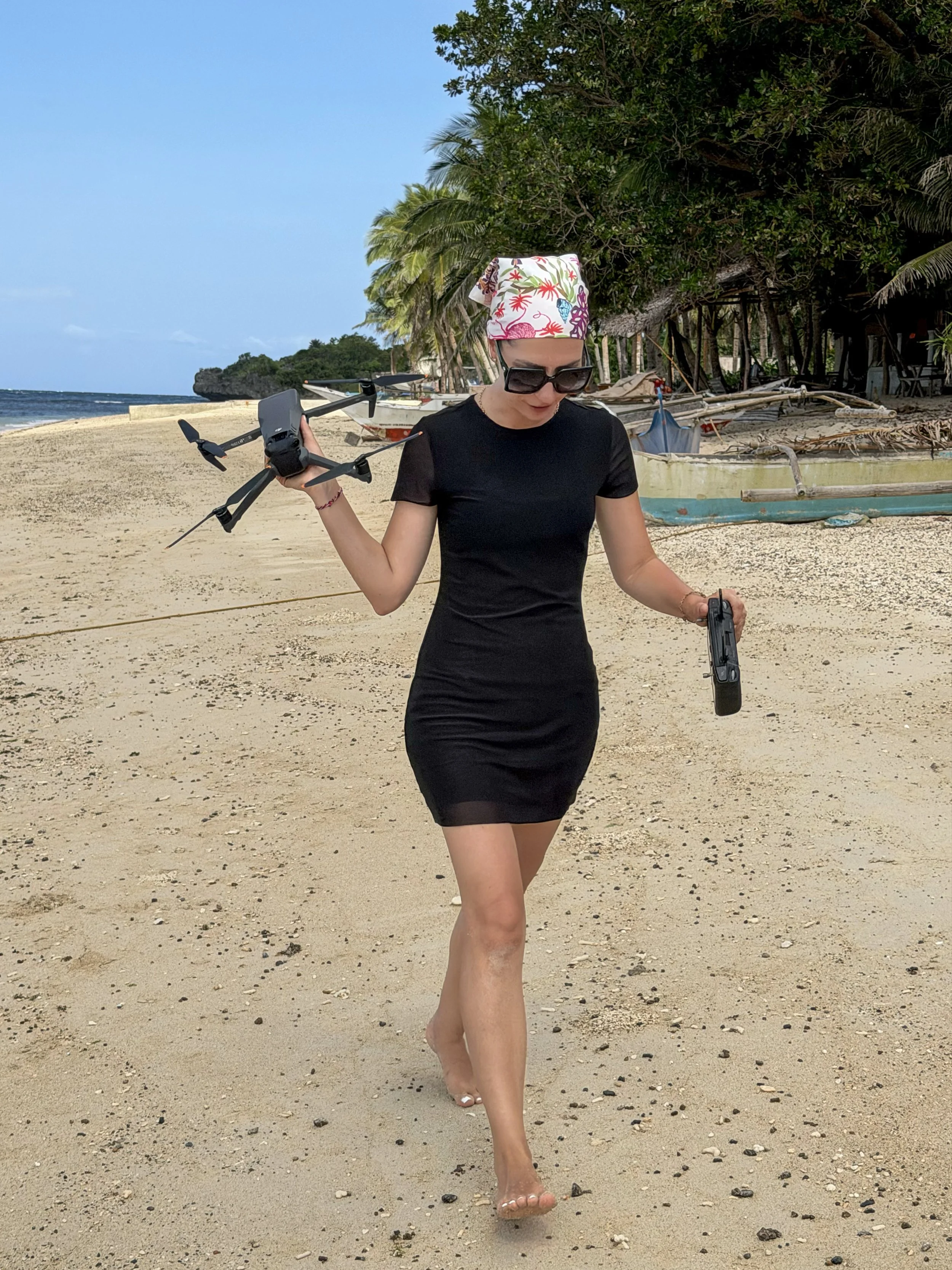 Anna Meshcheri is walking on a beach in Philippines holding her drone