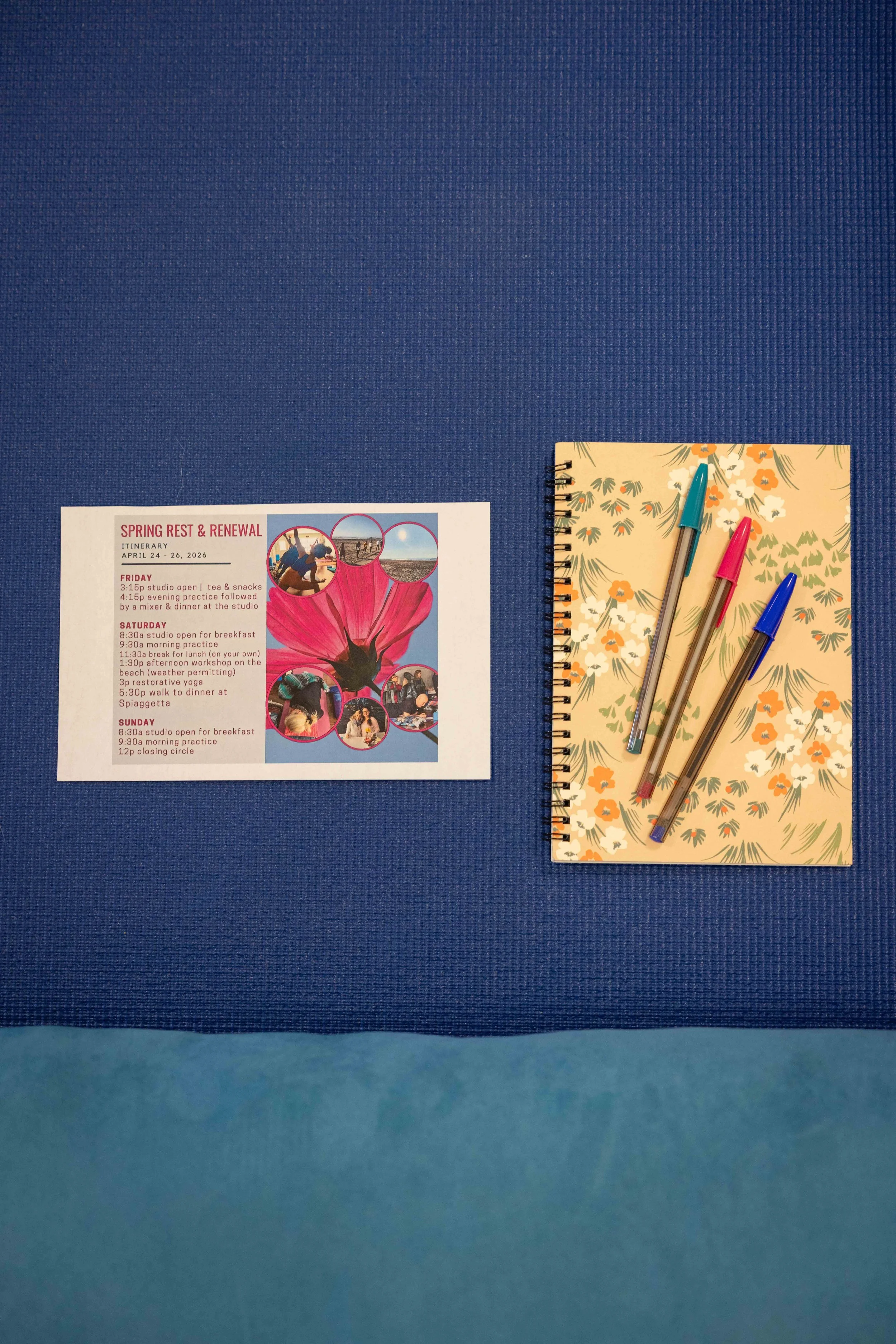 A blue textured background with a floral-themed spiral notebook and three pens on it, along with a printed itinerary for a trip titled "Spring Rest & Renewal" dated April 24 to 26, 2026.