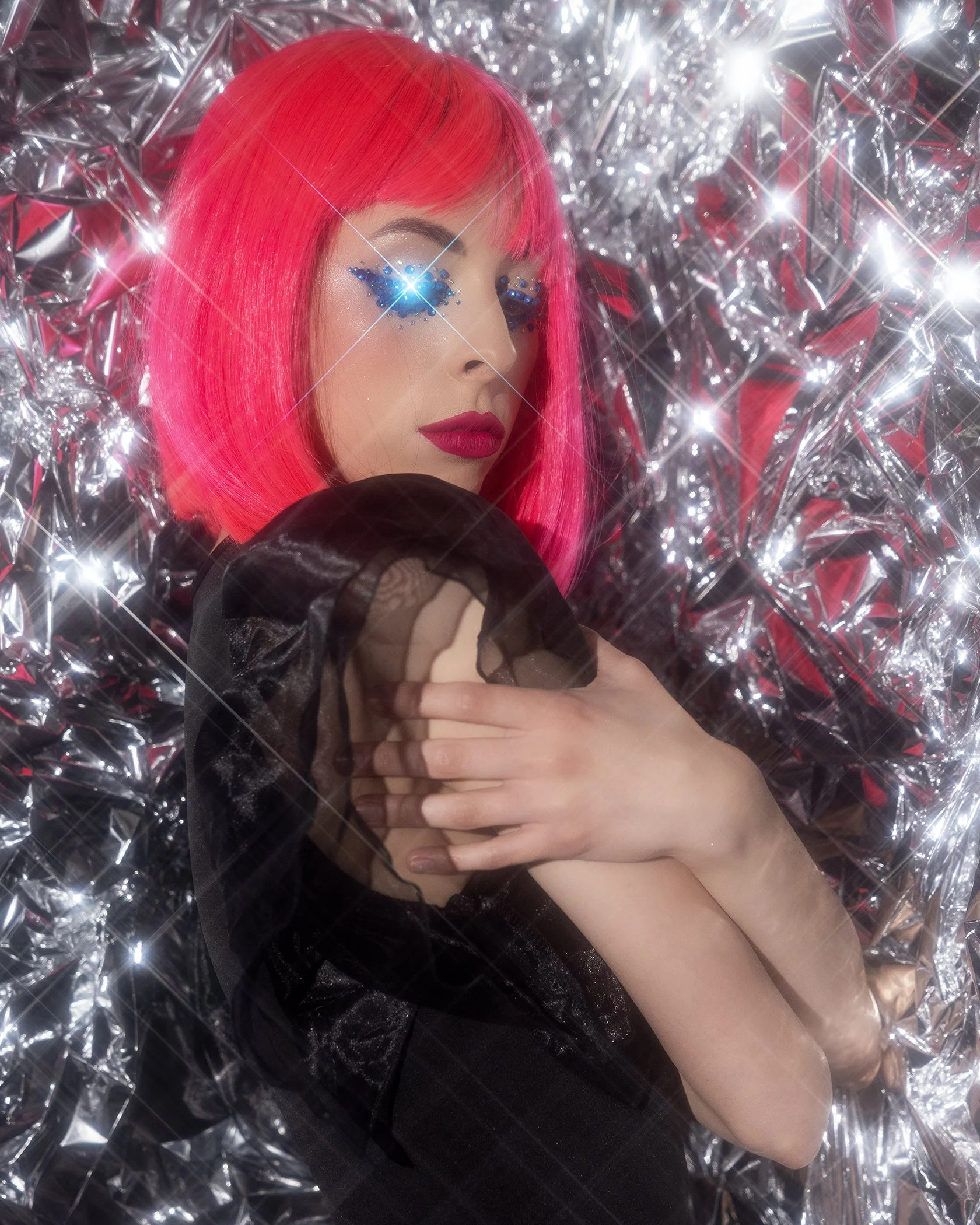 Creative portrait with starburst filter effect on reflective silver mylar background