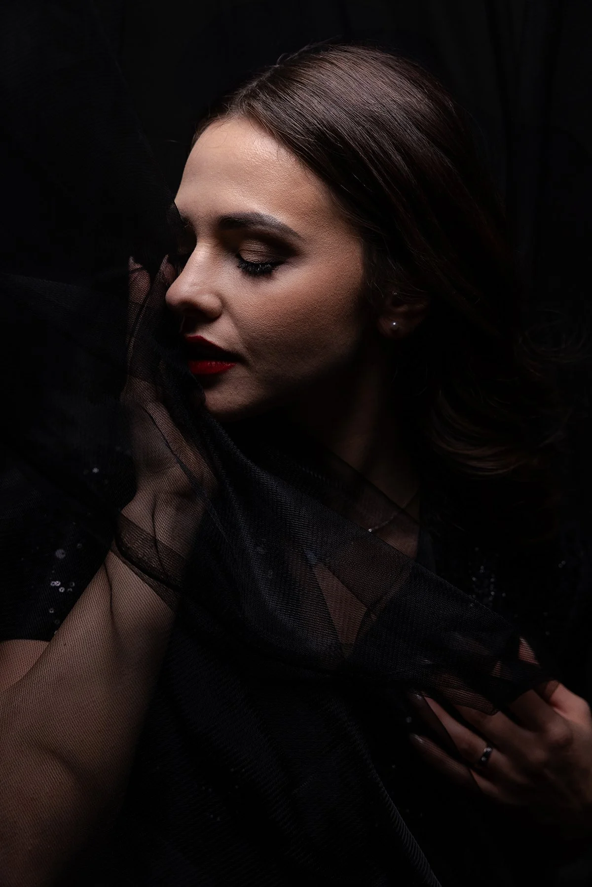 A closeup photo of a model posing with black tulle for an editorial studio photoshoot