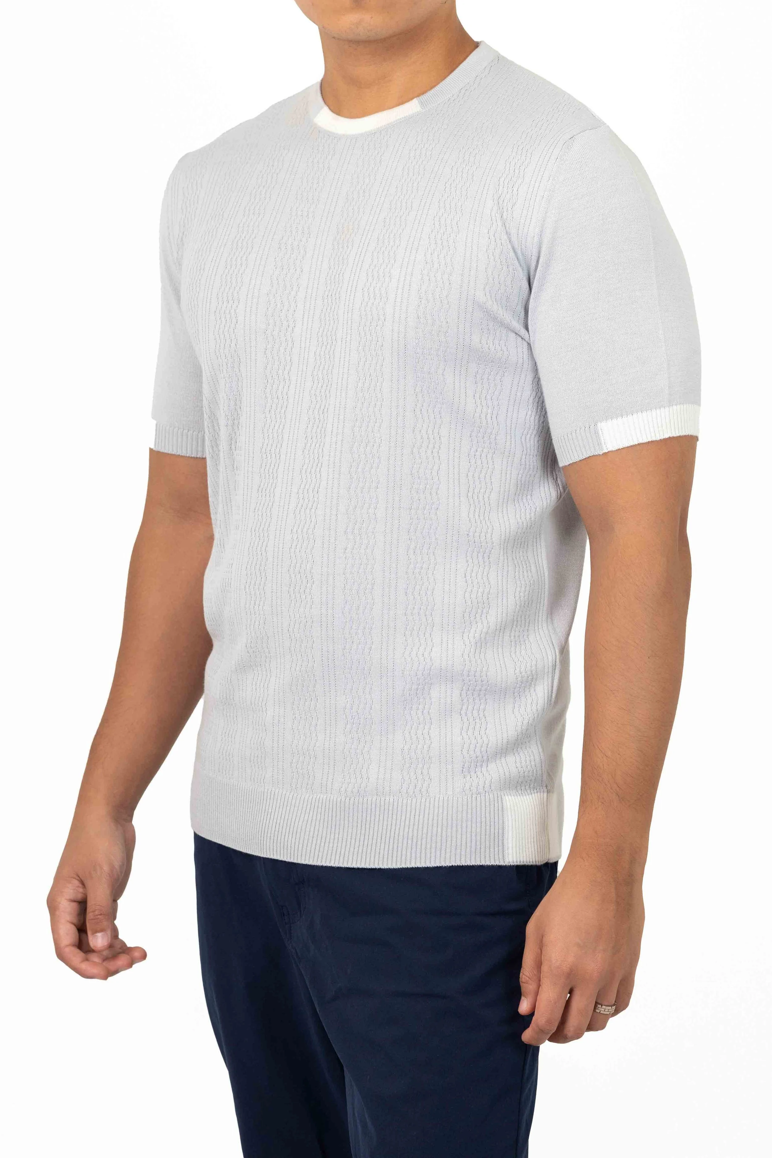 Man wearing a light gray short-sleeved sweater and dark pants. Catalogue Photography. Photographed by Anna Meshcheri