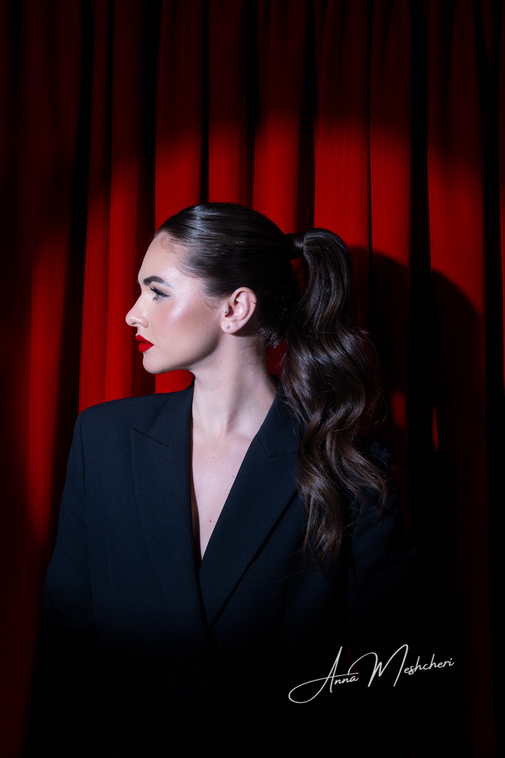 Studio fashion portrait with Hollywood glam styling, red curtains, dramatic lighting, and a sleek editorial beauty look.