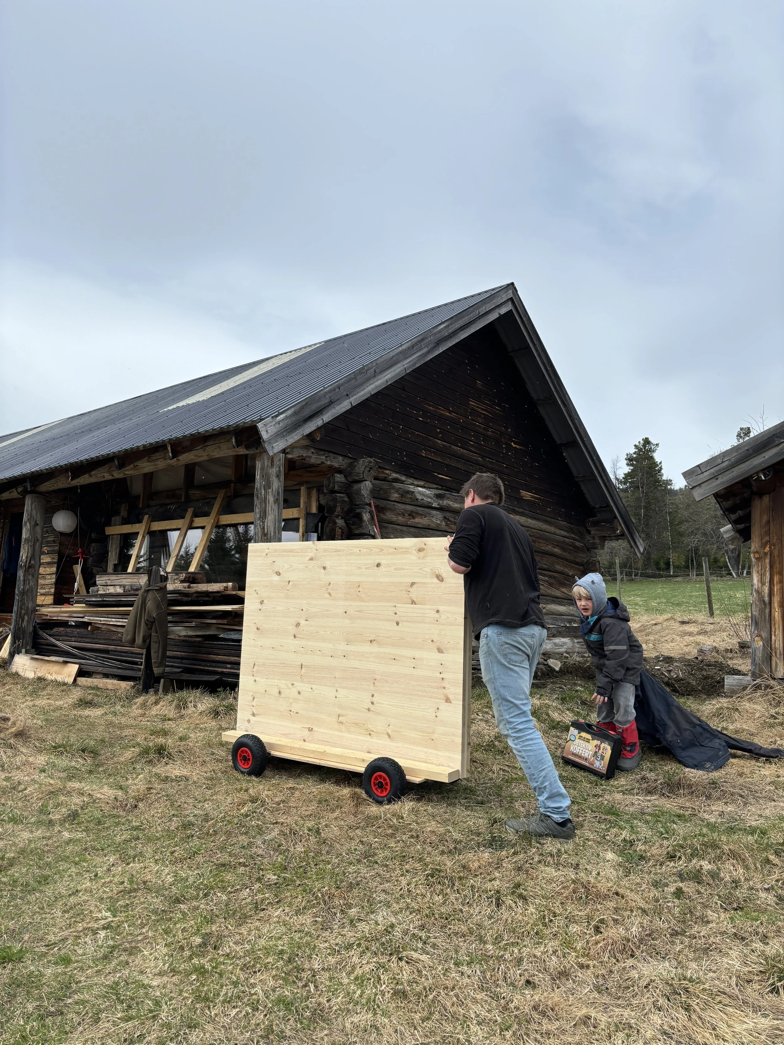 Massivtre elementene blir trillet inn til låven på en Olabil.