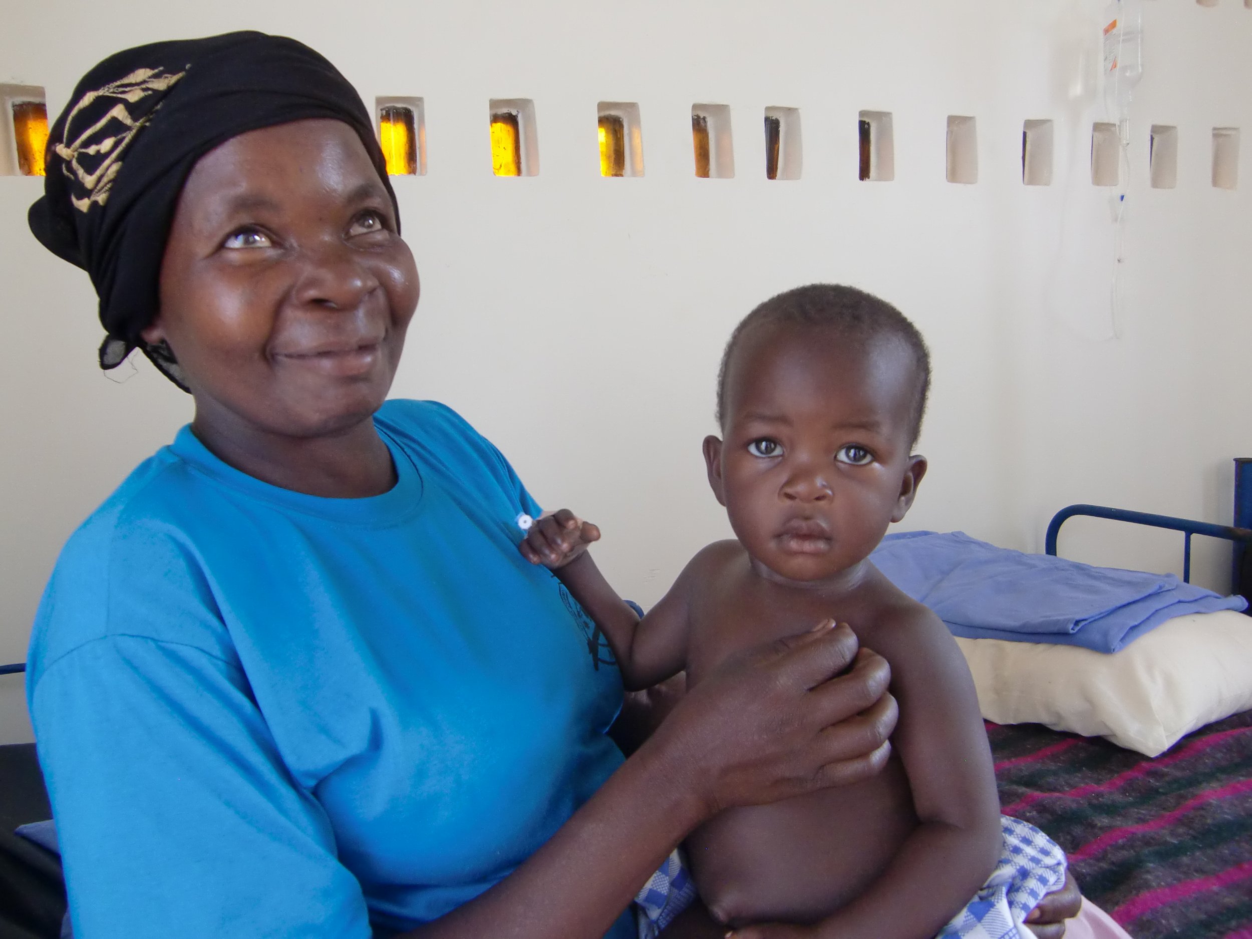 Campusen ligger rett ved Niles Brewery og vi fik skaffet gamle brune ølflasker fra bryggeriet, hentet det i søppelsekker og murte de opp ned inn i veggen. Etterpå har dette blitt en måte å lage lys i huset i området rundt.