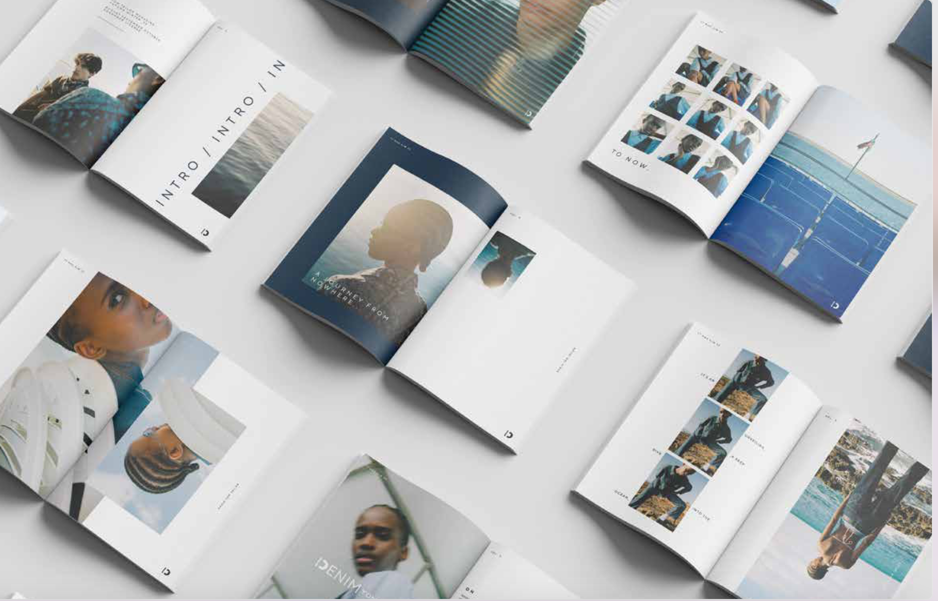 Open magazines displaying photographs of people, fashion, and outdoor scenes spread on a light surface.