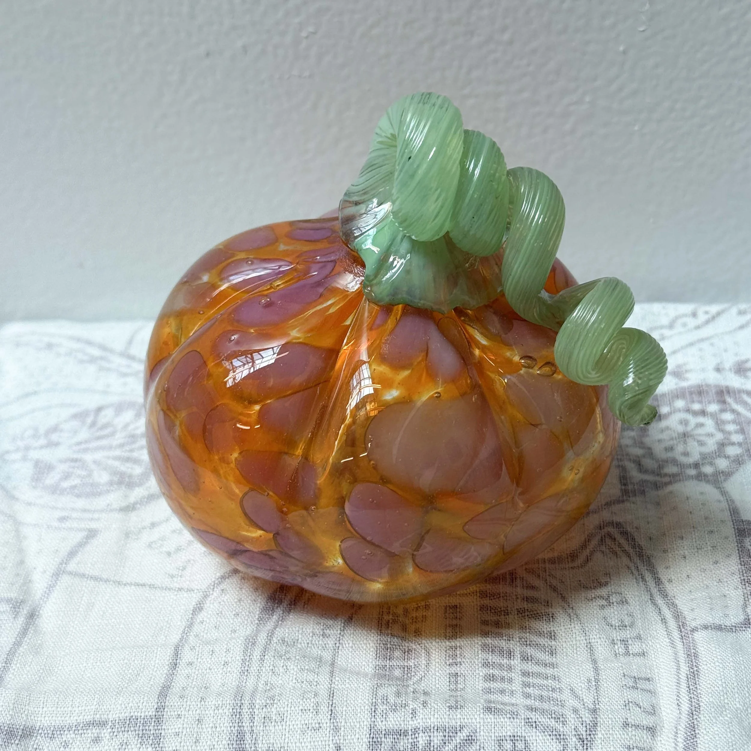 orange and pink pumpkin with light green stem