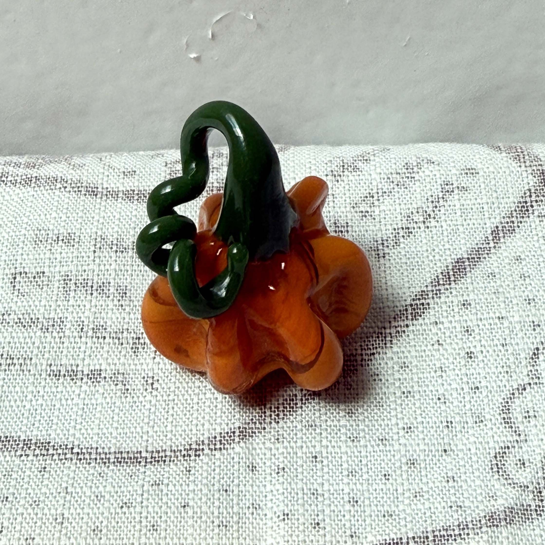 orange mini pumpkin with dark green stem