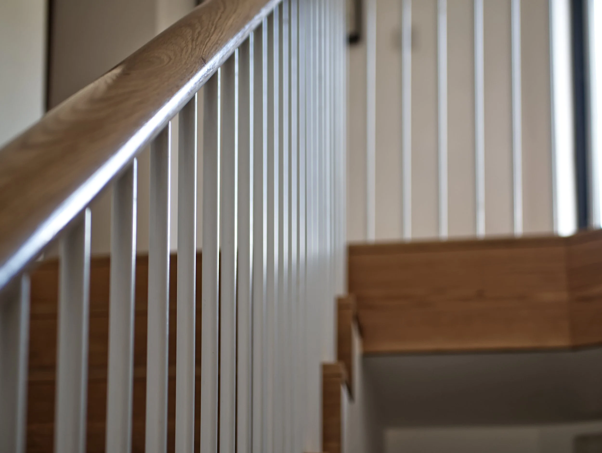 Timber staircase with white metal spindles and exposed treads and risers