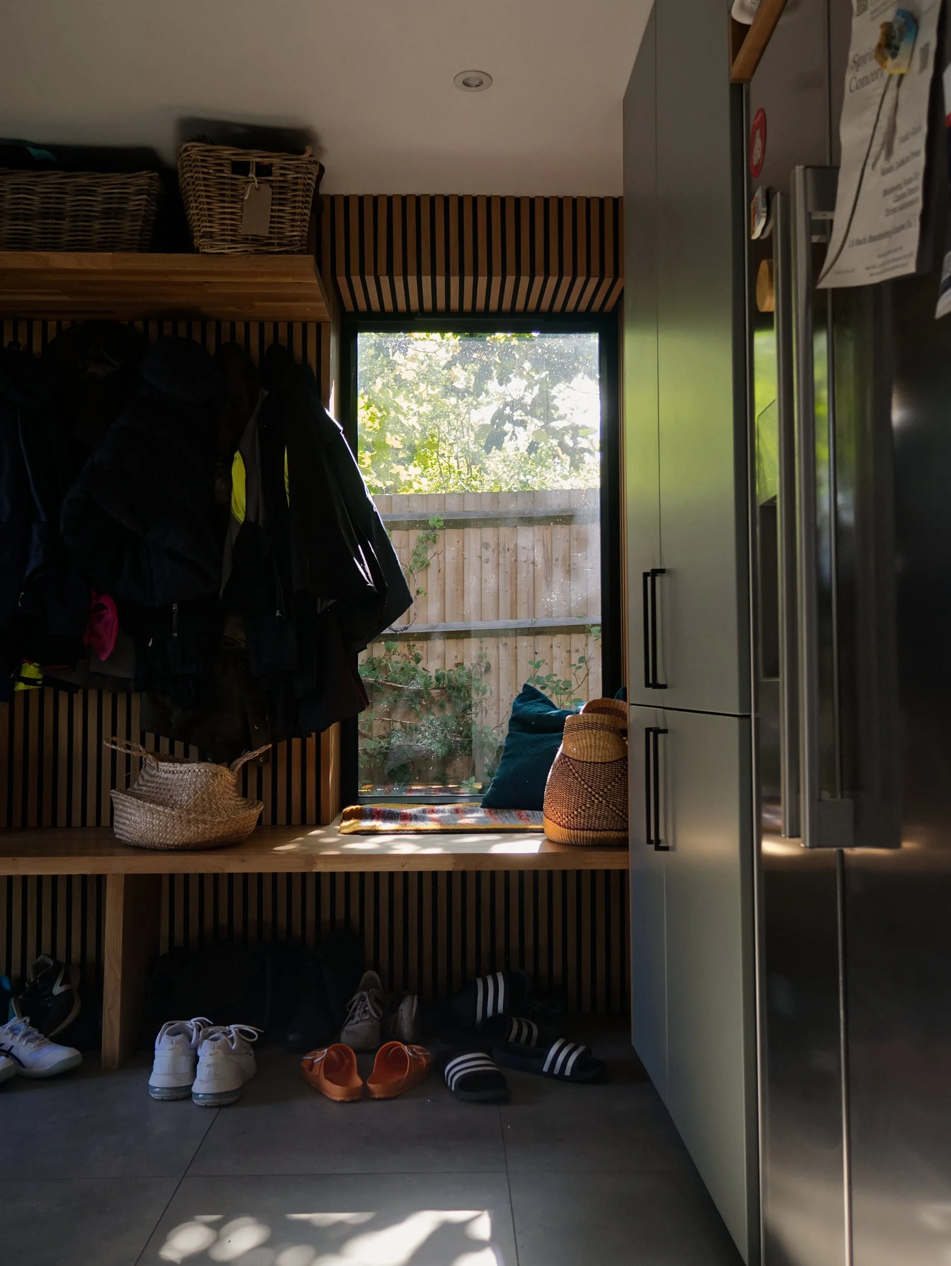 Boot room with timber panelling and joinery framing a window seat