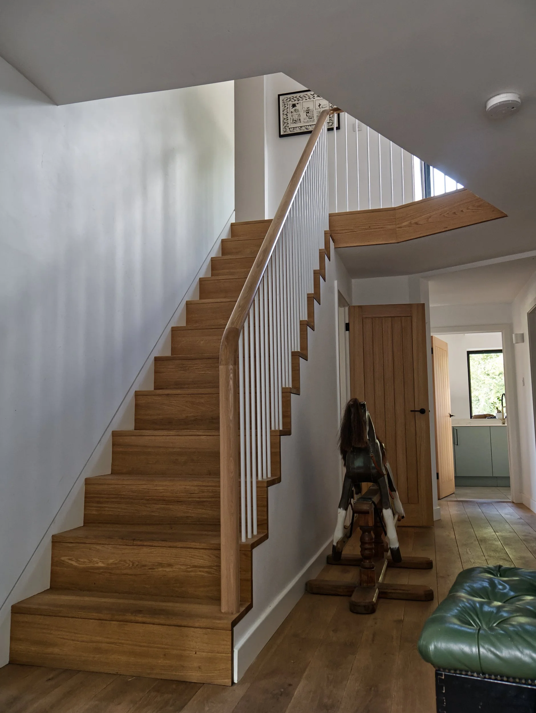 Timber staircase with white metal spindles and exposed treads and risers