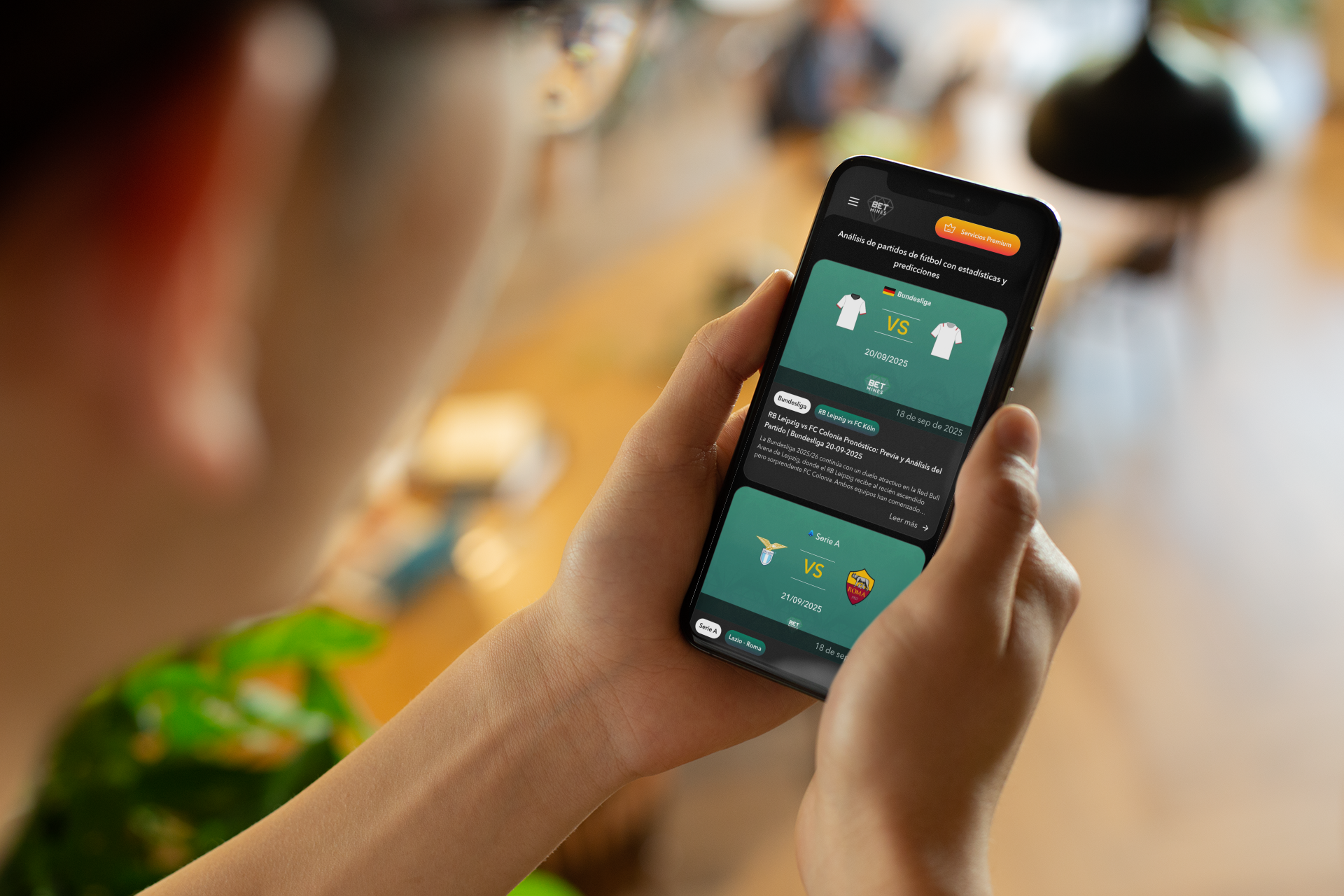 Person holding a smartphone displaying a sports betting app with upcoming soccer matches and odds.