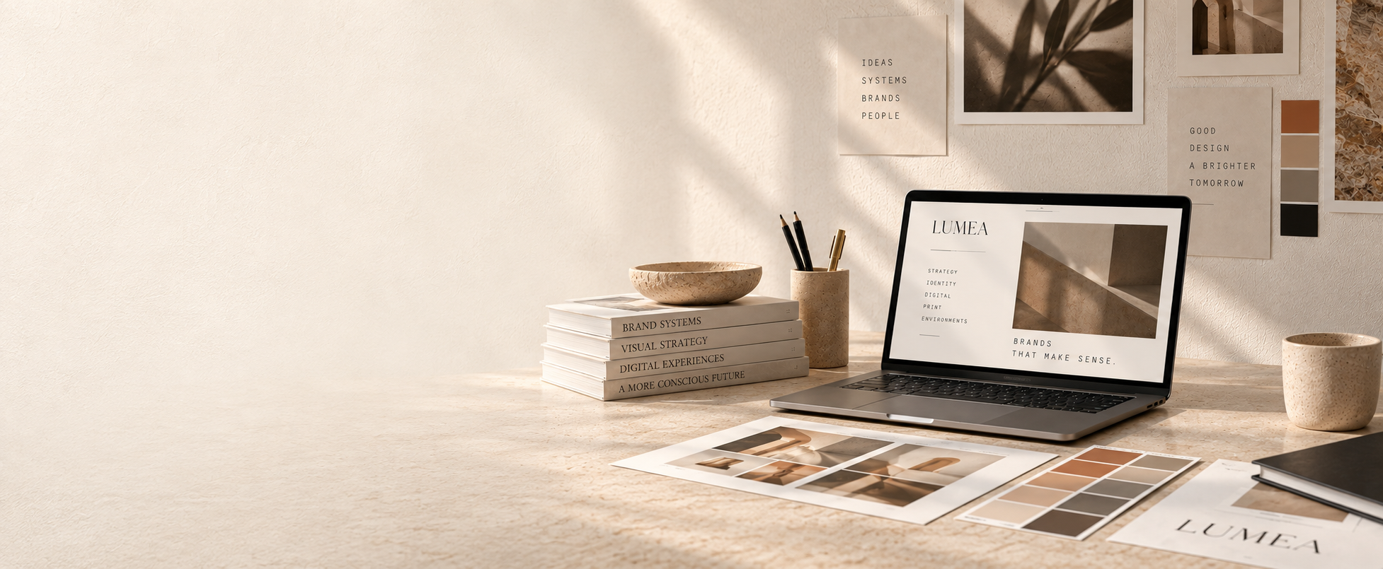 LUMEA studio desk with brand books, laptop, and color swatches
