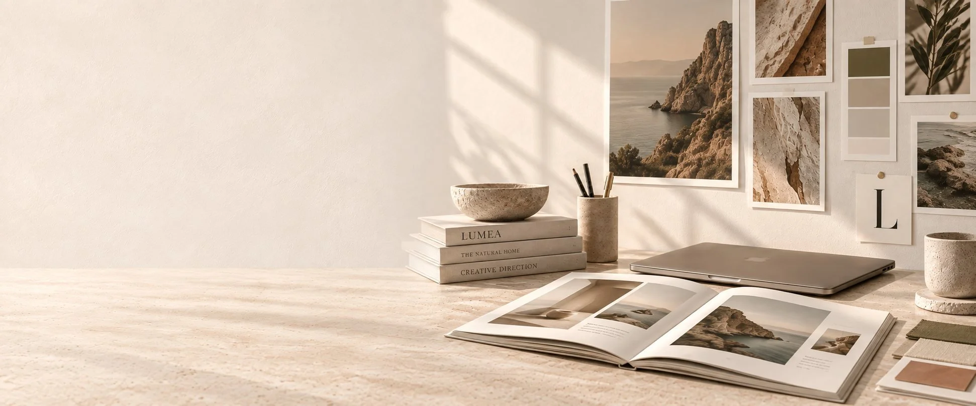 Open book, notebooks and a moodboard on a LUMEA studio desk