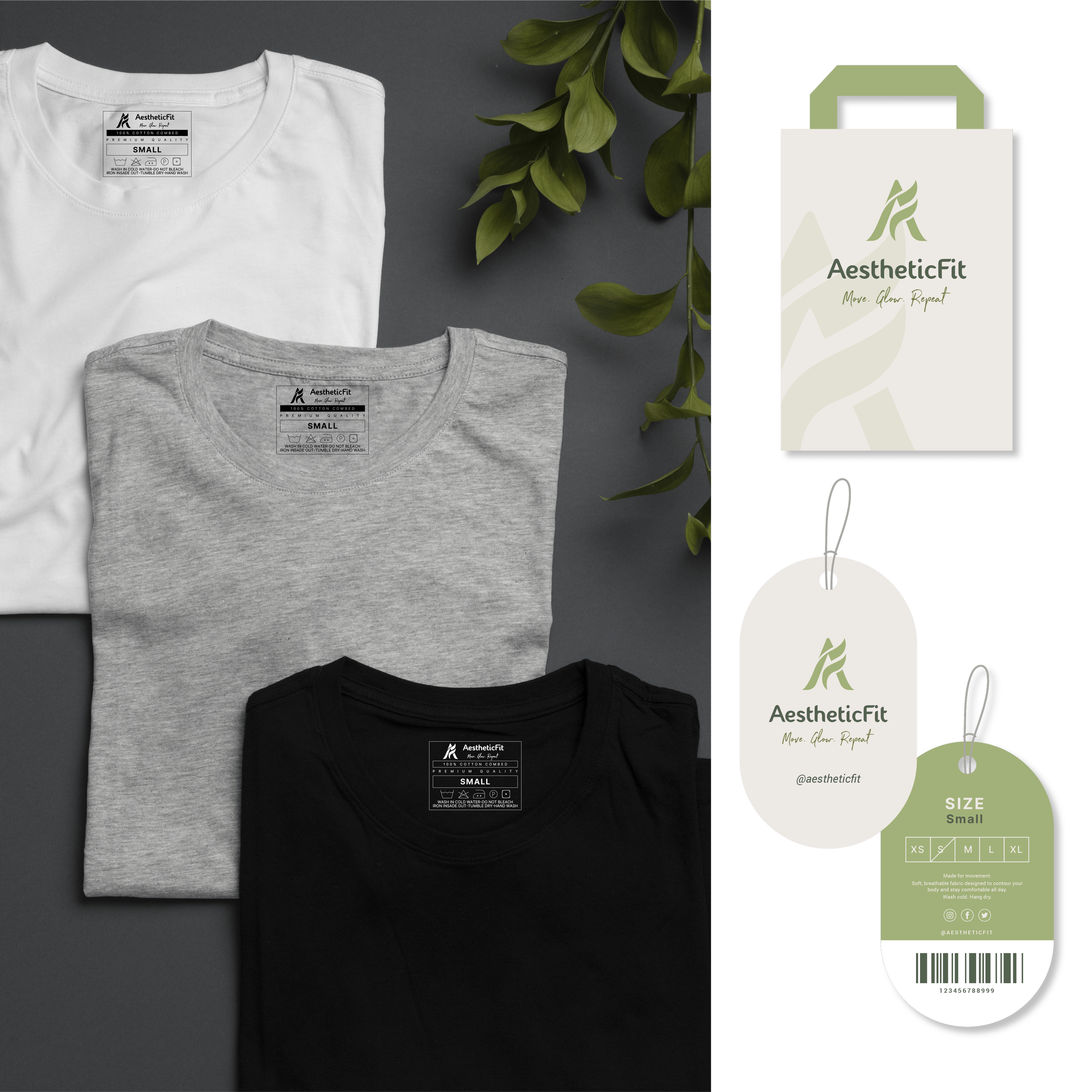 Three folded T-shirts in white, gray, and black laid out on a gray background, with green foliage to the upper right, and AestheticFit branded tags and packaging to the right.