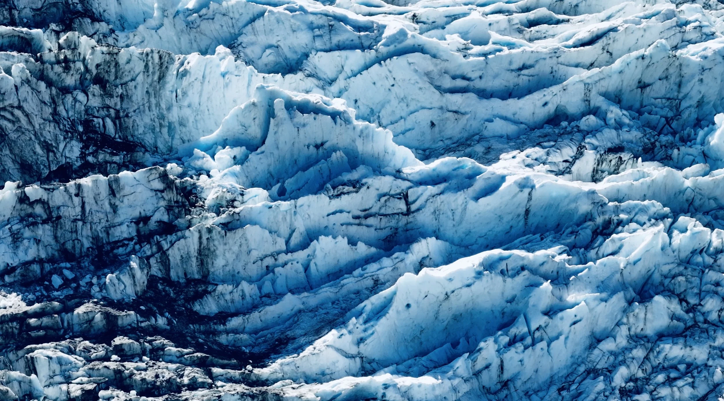 Close-up view of a glacier with blue ice and visible crevasses.