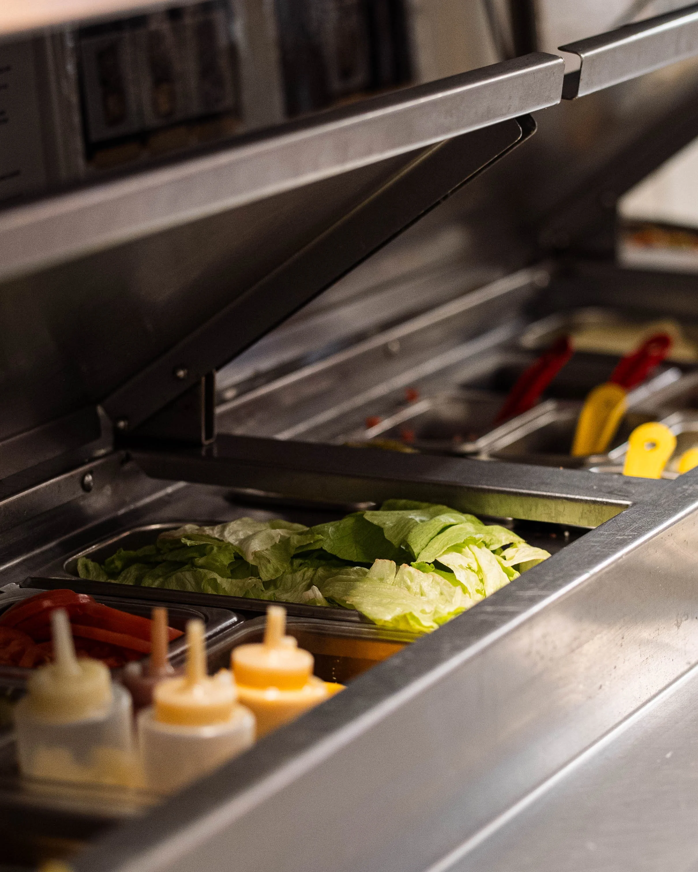 Lettuce ready for preparation in a stainless steel food warmer.