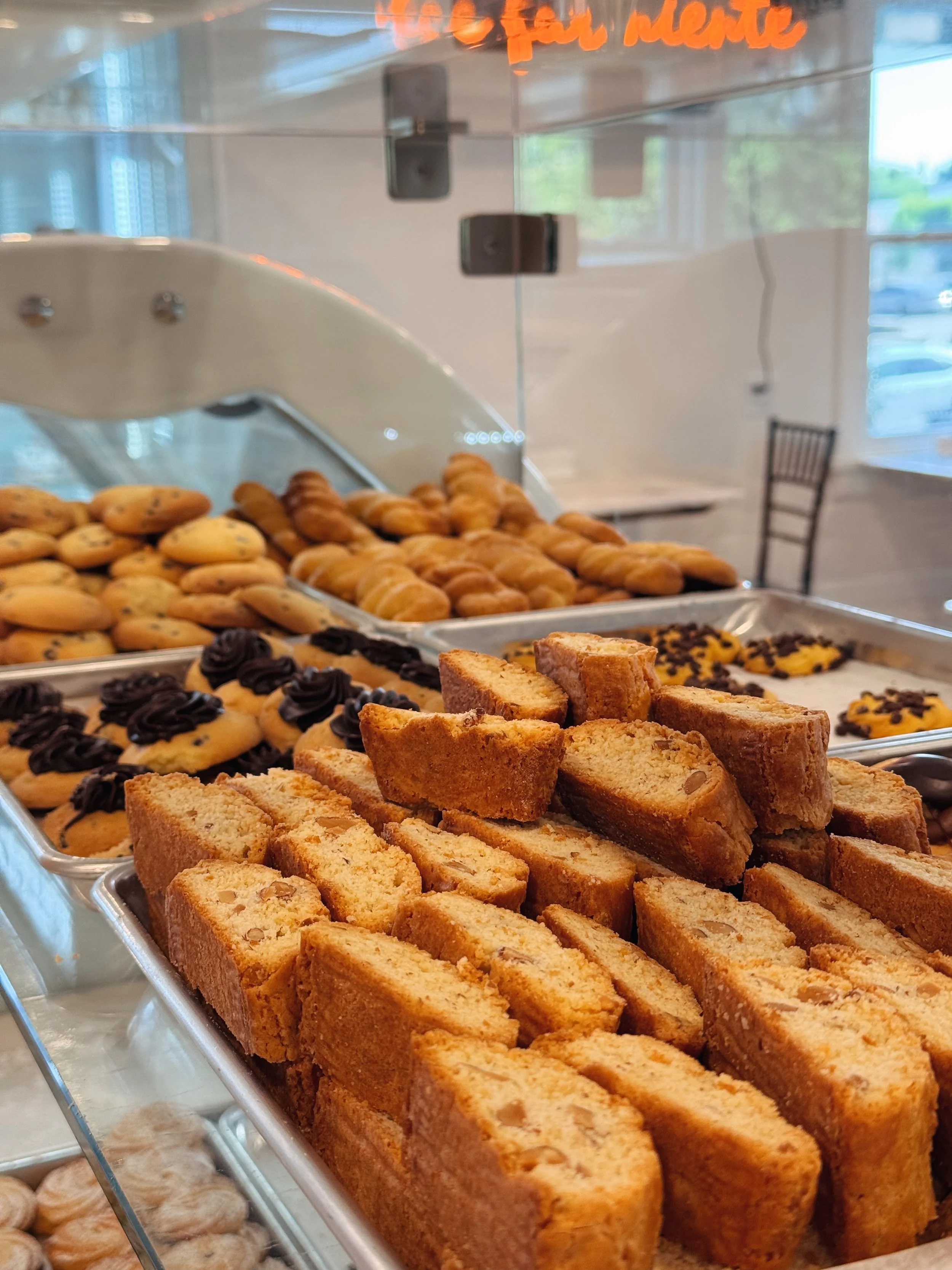 Assorted cookies, biscotti, and pastries displayed in a bakery case.