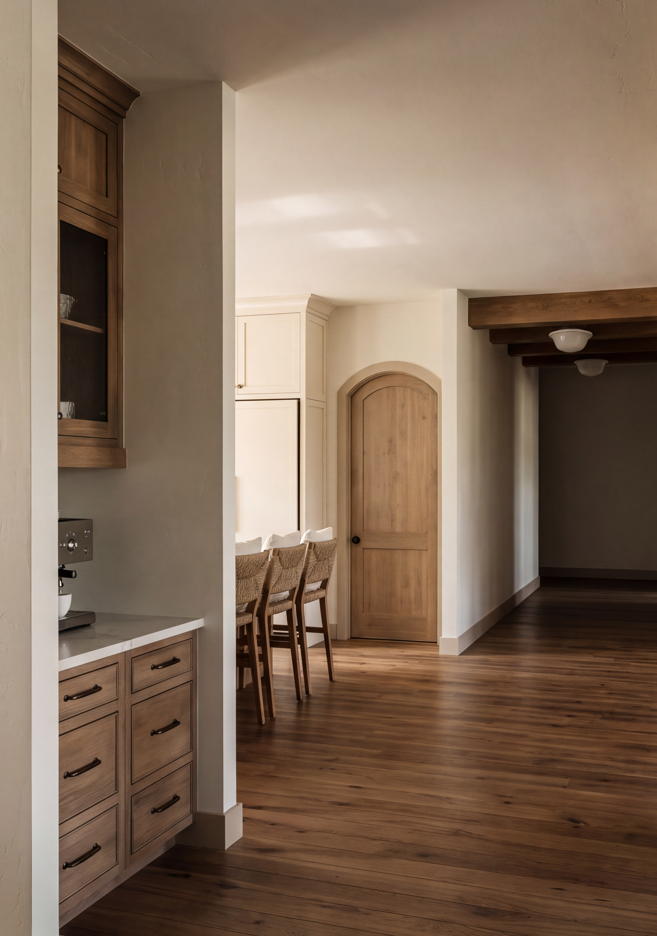 Interior view of a kitchen and dining area with wood furniture, wooden flooring, and a partially visible wooden cabinet and door.