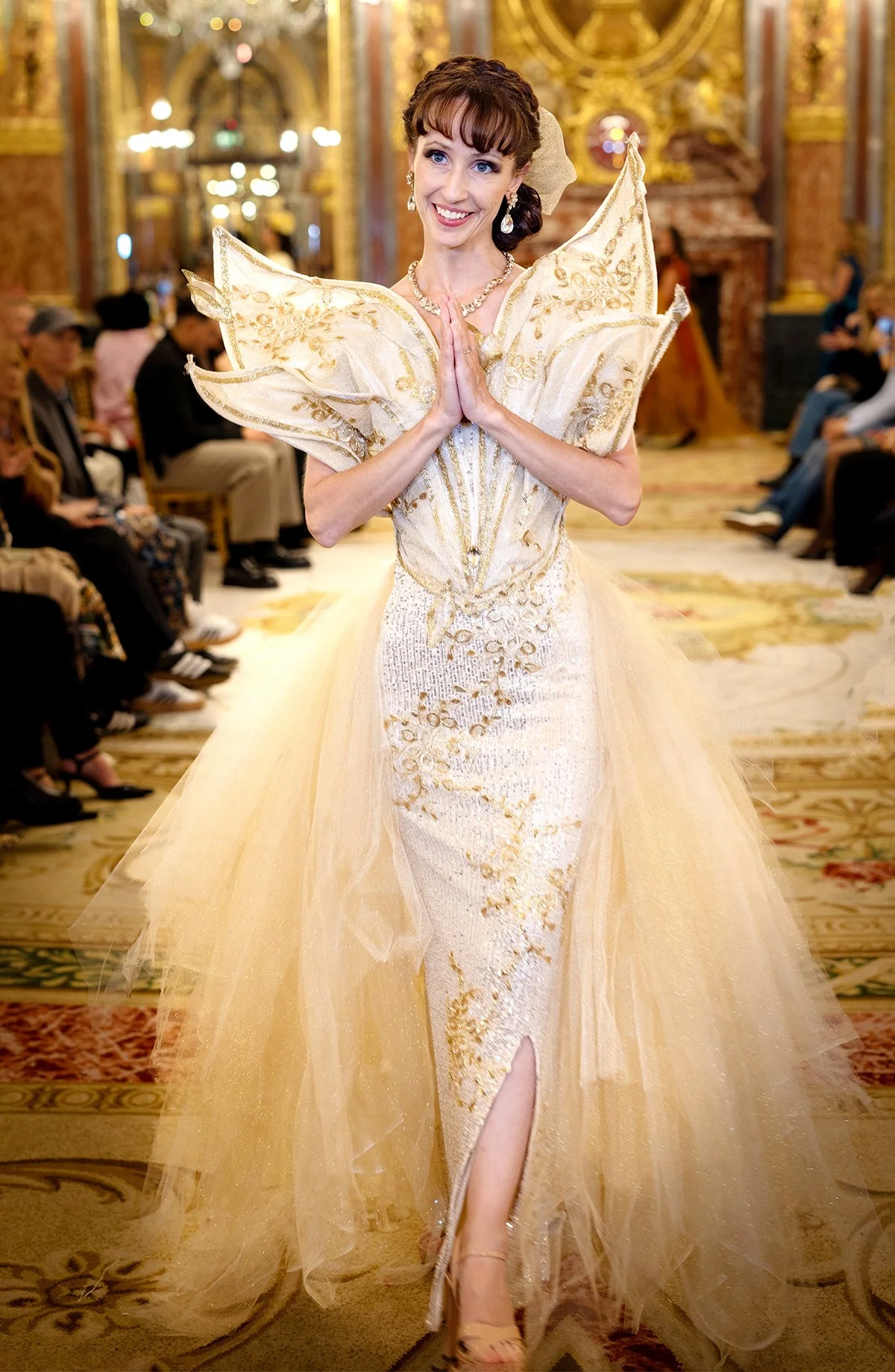 Woman wearing a golden wings dress at paris Fashion Week for Unfinished Wings-a suicide prevention project