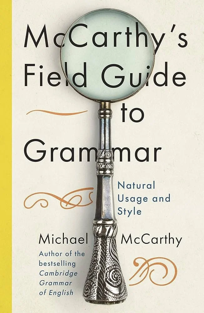 Book titled 'McCarthy's Field Guide to Grammar: Natural Usage and Style' by Michael McCarthy, featuring a magnifying glass placed over the cover.