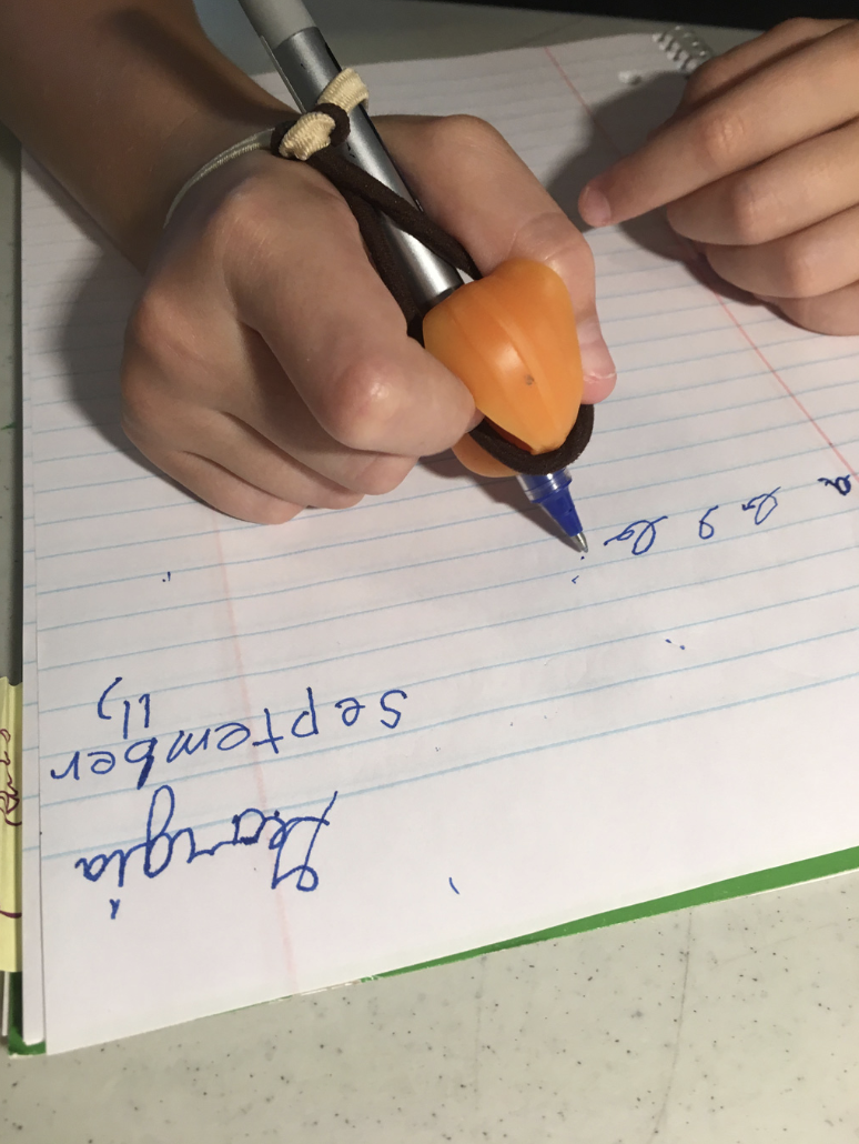 Child practicing handwriting with a grip pen during dyslexia tutoring