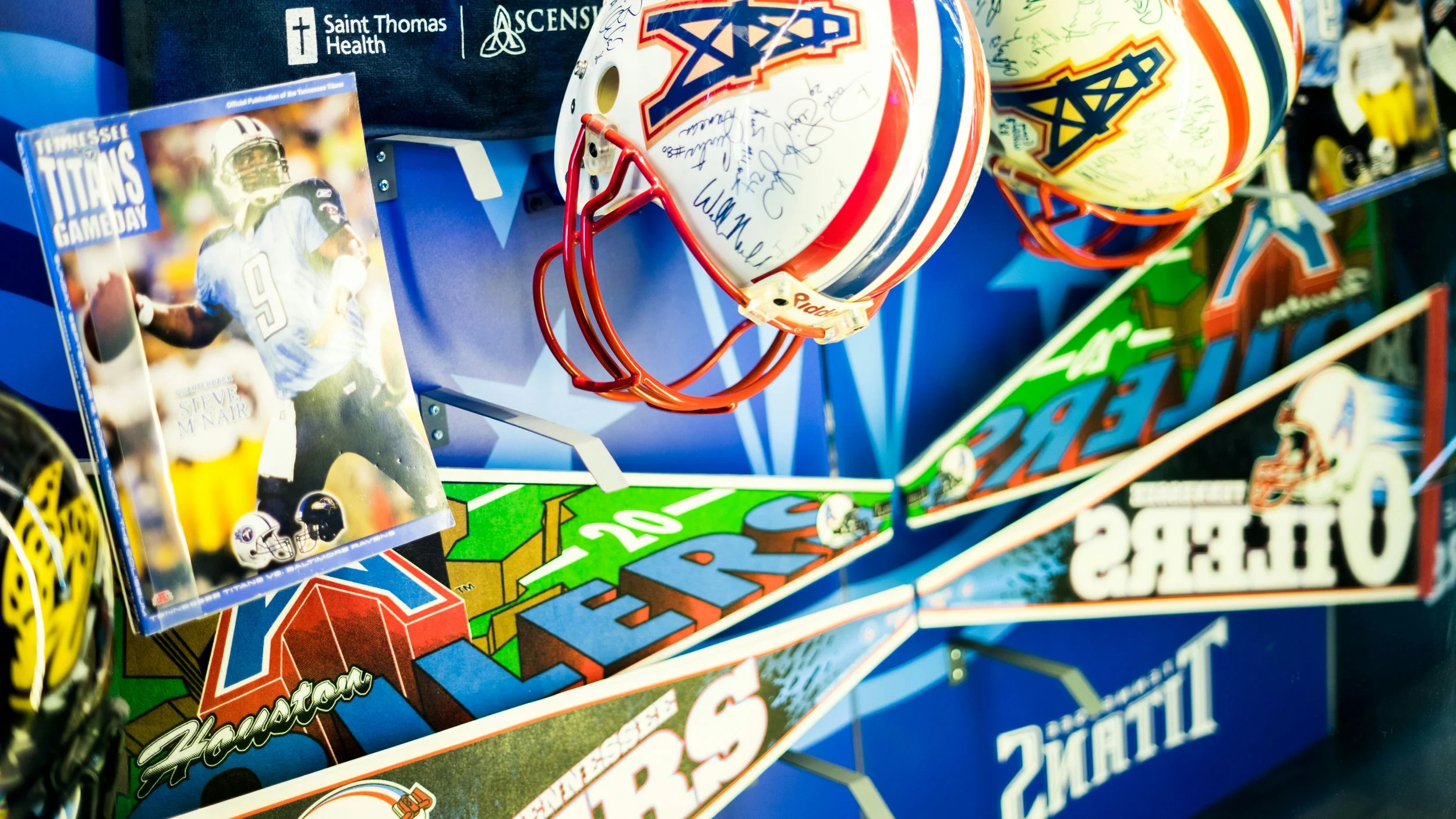 Pinball machine themed around American football, featuring a signed football helmet and a football card, with colorful artwork and branding for the Oilers and Houston Texans.