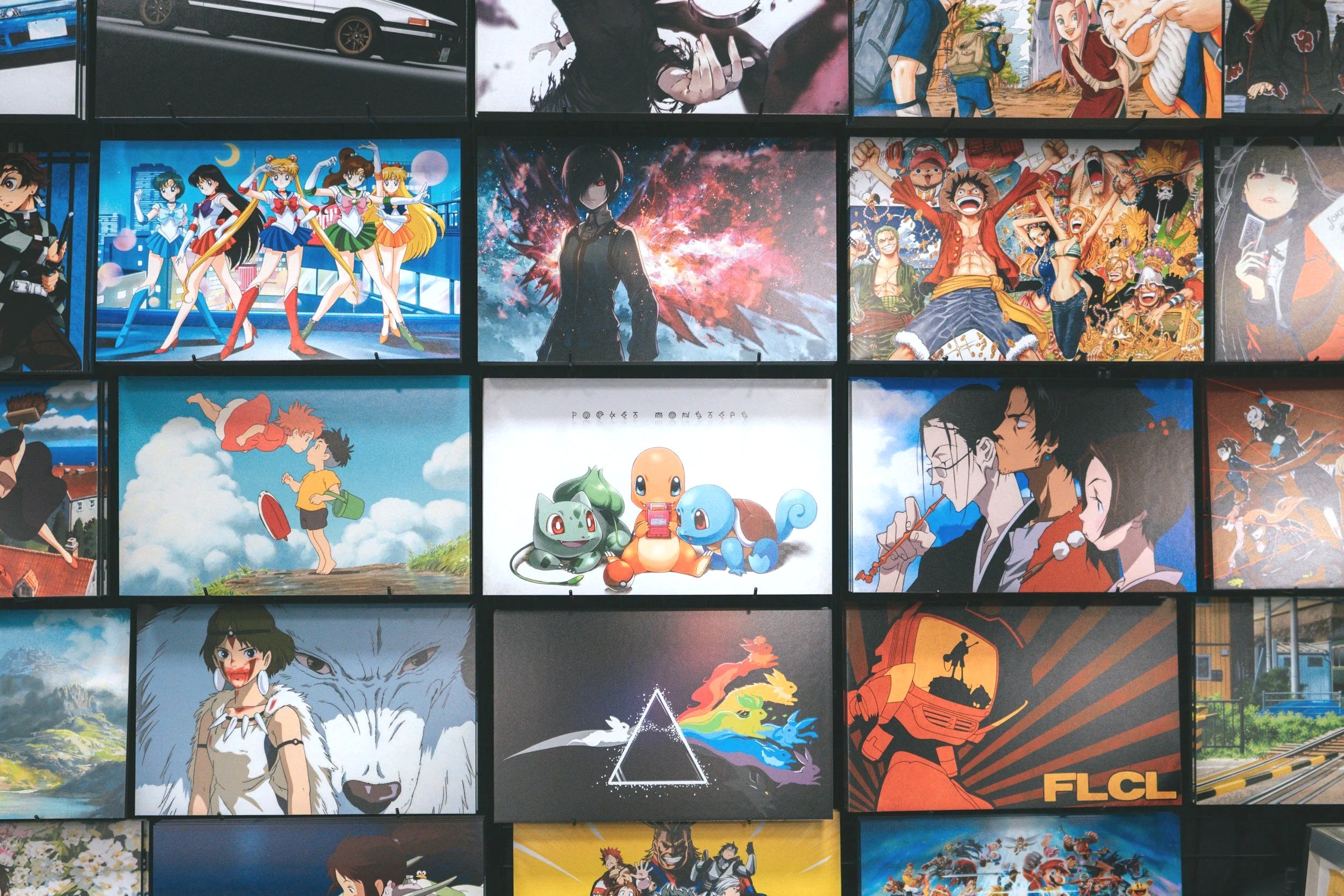 A collage of various colorful animated and manga characters from different anime series and movies displayed on a wall or screen.