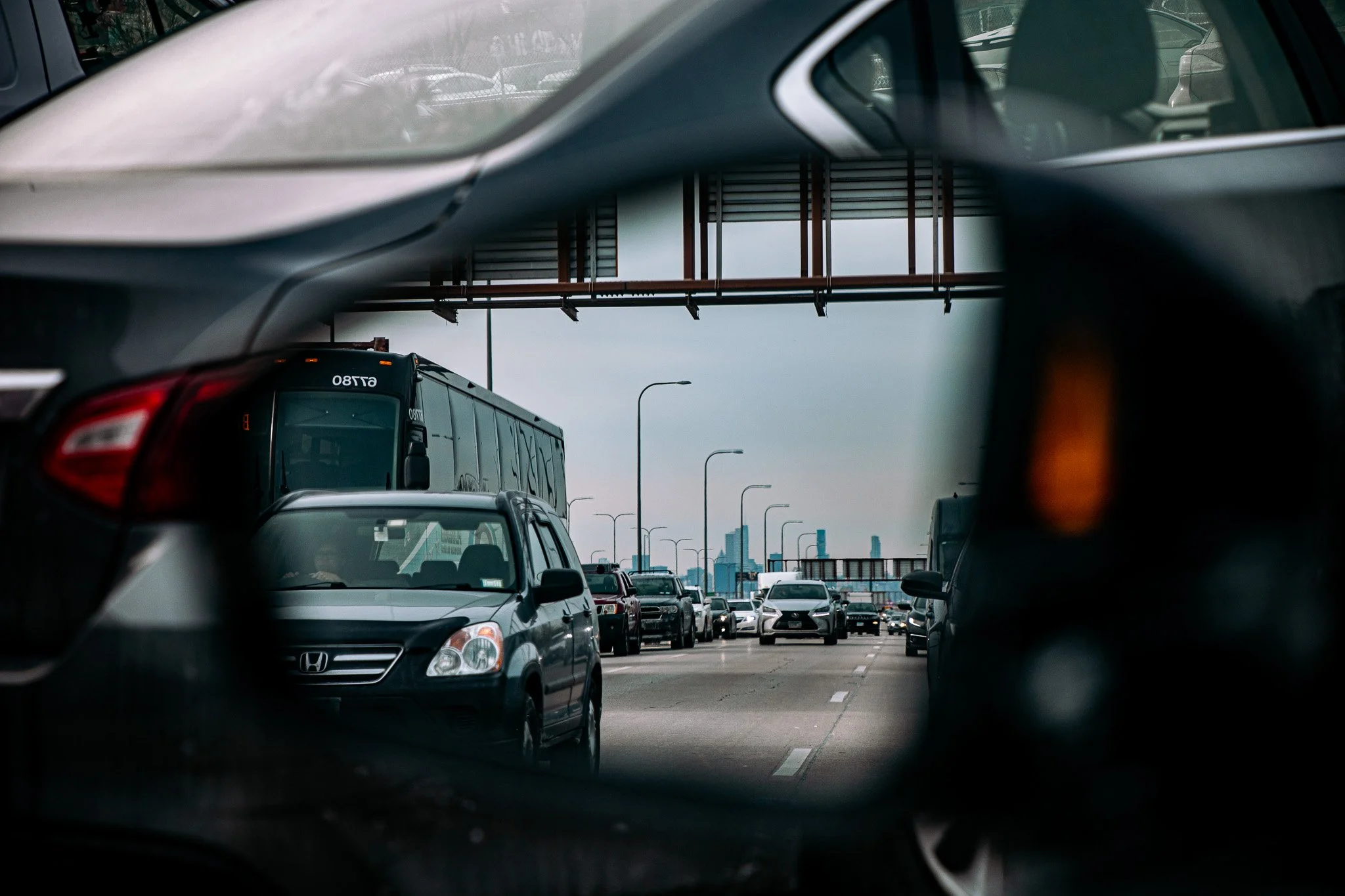Traffic jam on highway with side mirror reflection showing queue of vehicles including cars and a bus.