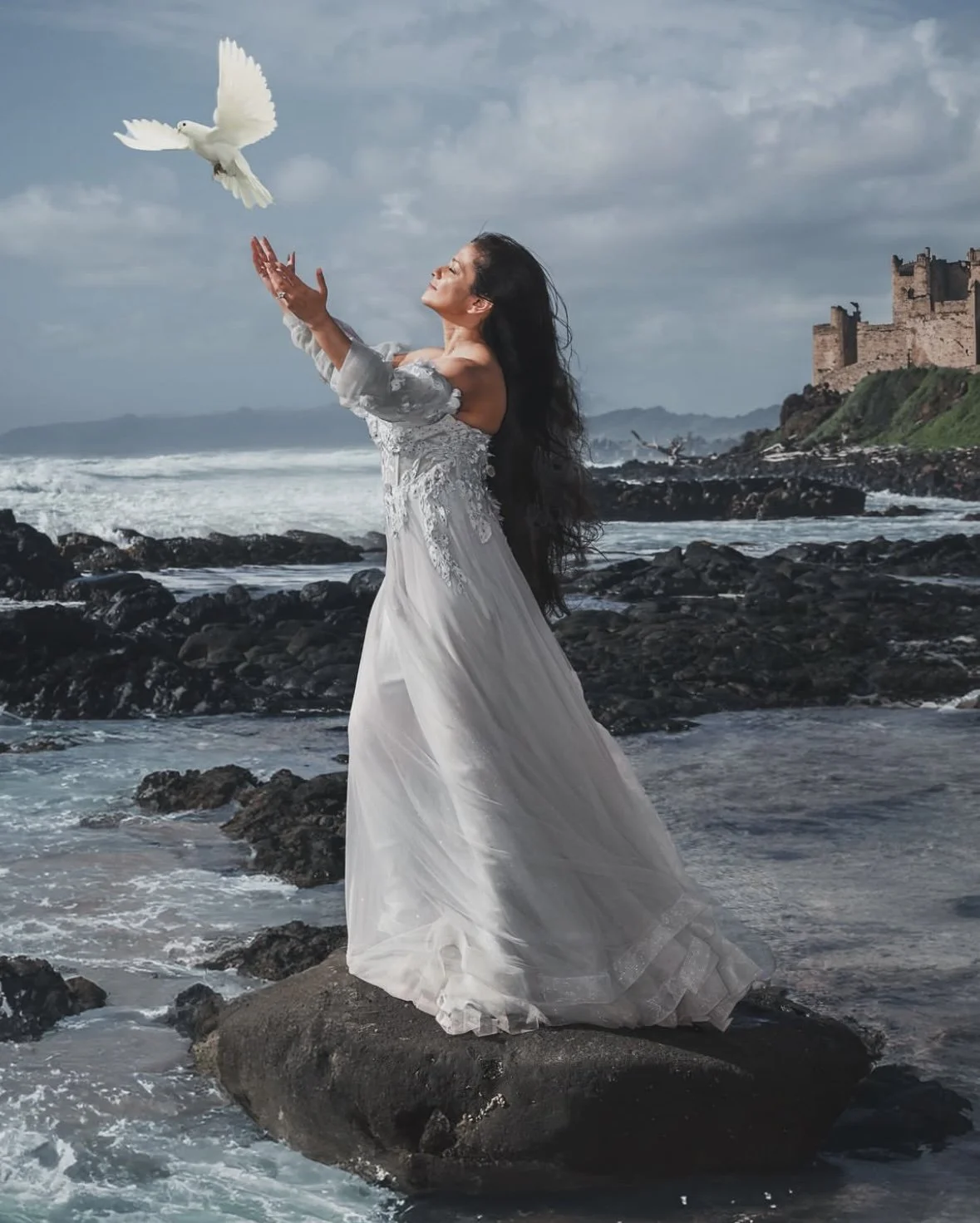 Woman in blue flying dress on rocky beach (Cozumel-inspired photoshoot)
