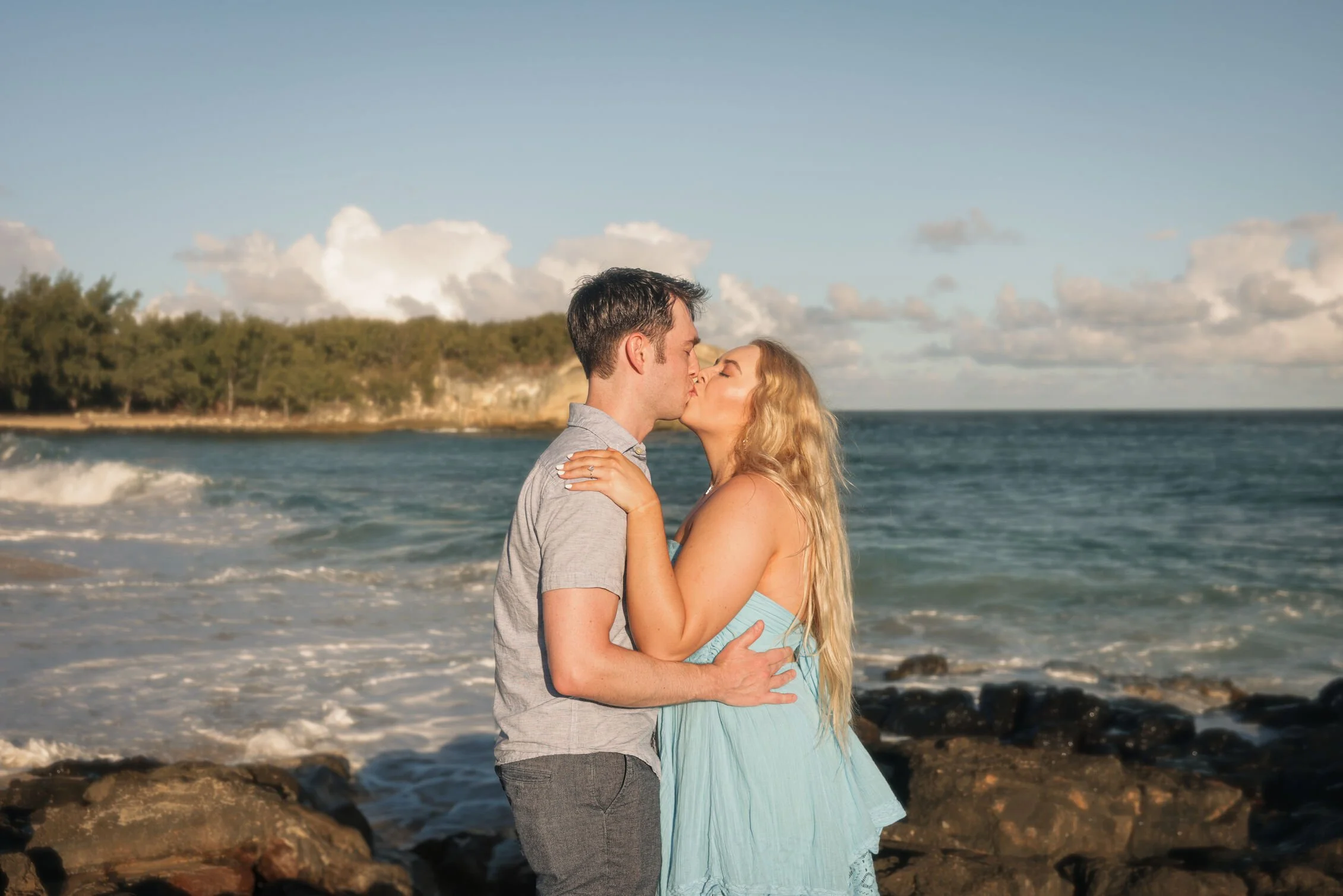 Romantic beach photoshoot of couple embracing under cloudy sky in Cozumel