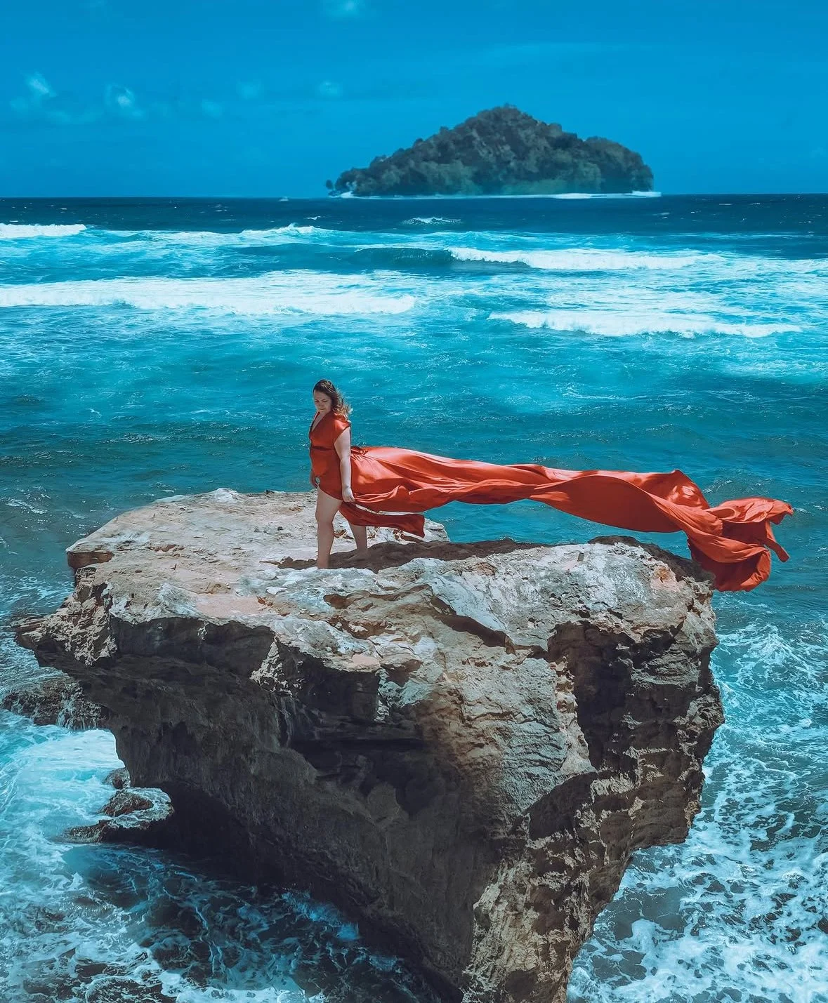 Cozumel artistic photoshoot of woman on rocks in flowing red dress