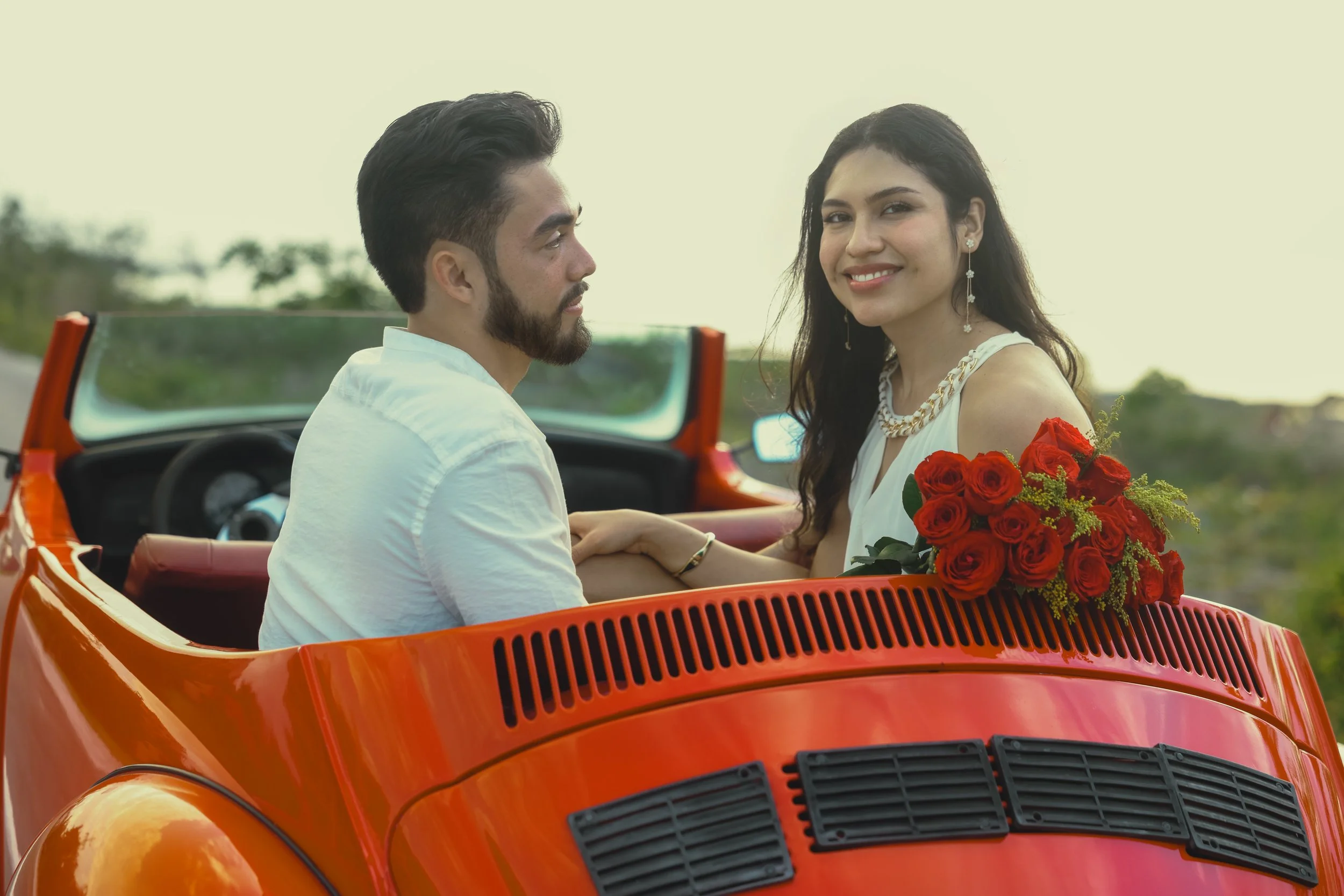 Bride and groom enjoying a scenic convertible ride for wedding photos in Cozumel