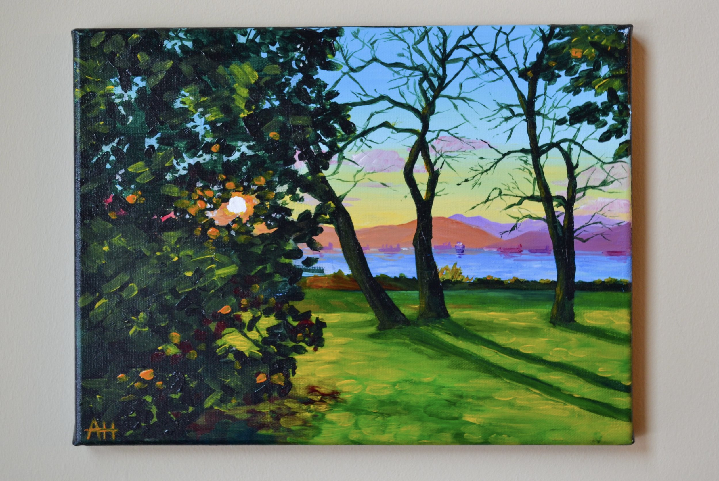 A vibrant landscape painting depicting trees and shrubs in the foreground with a setting sun, a blue body of water, and mountains in the background.