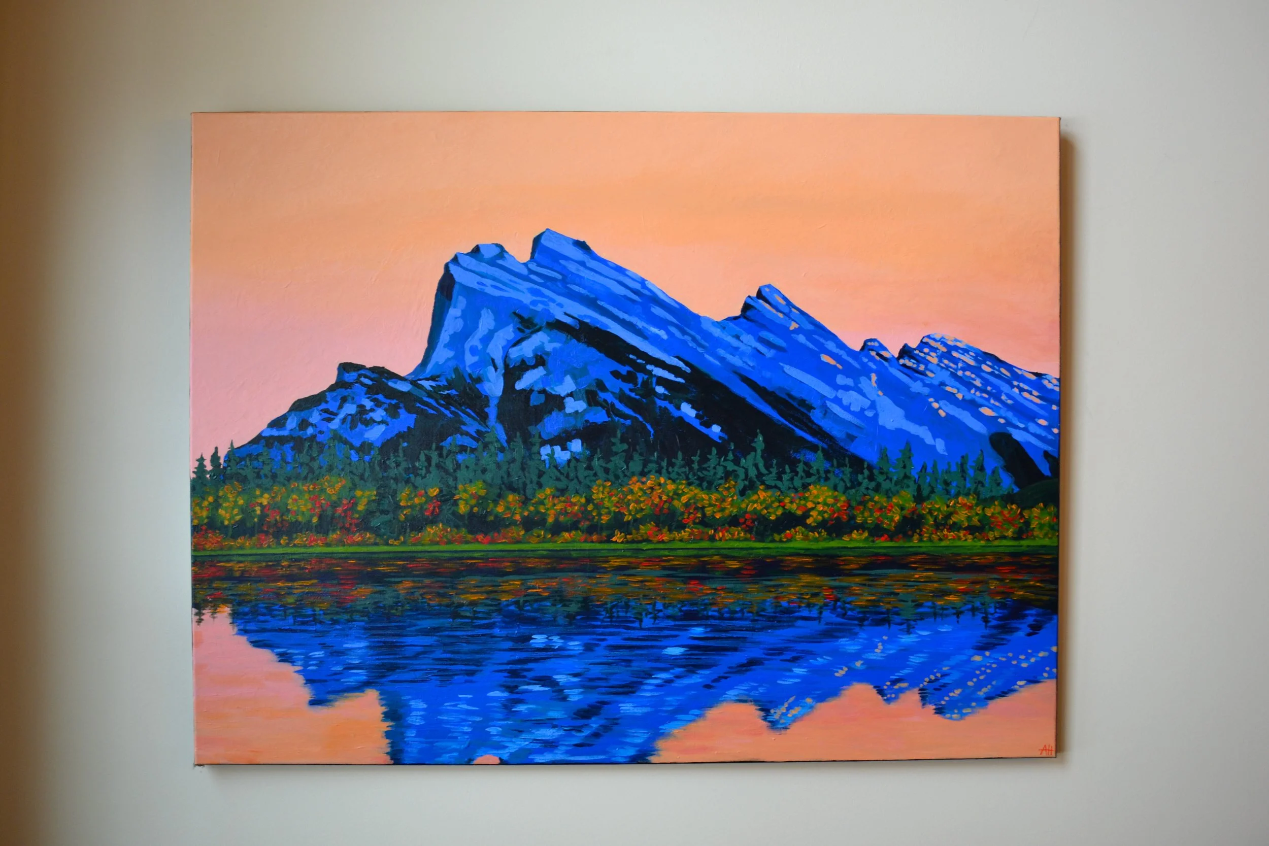 Colorful mountain landscape painting with blue mountains, vibrant pink sky, and a forest reflected in a lake.