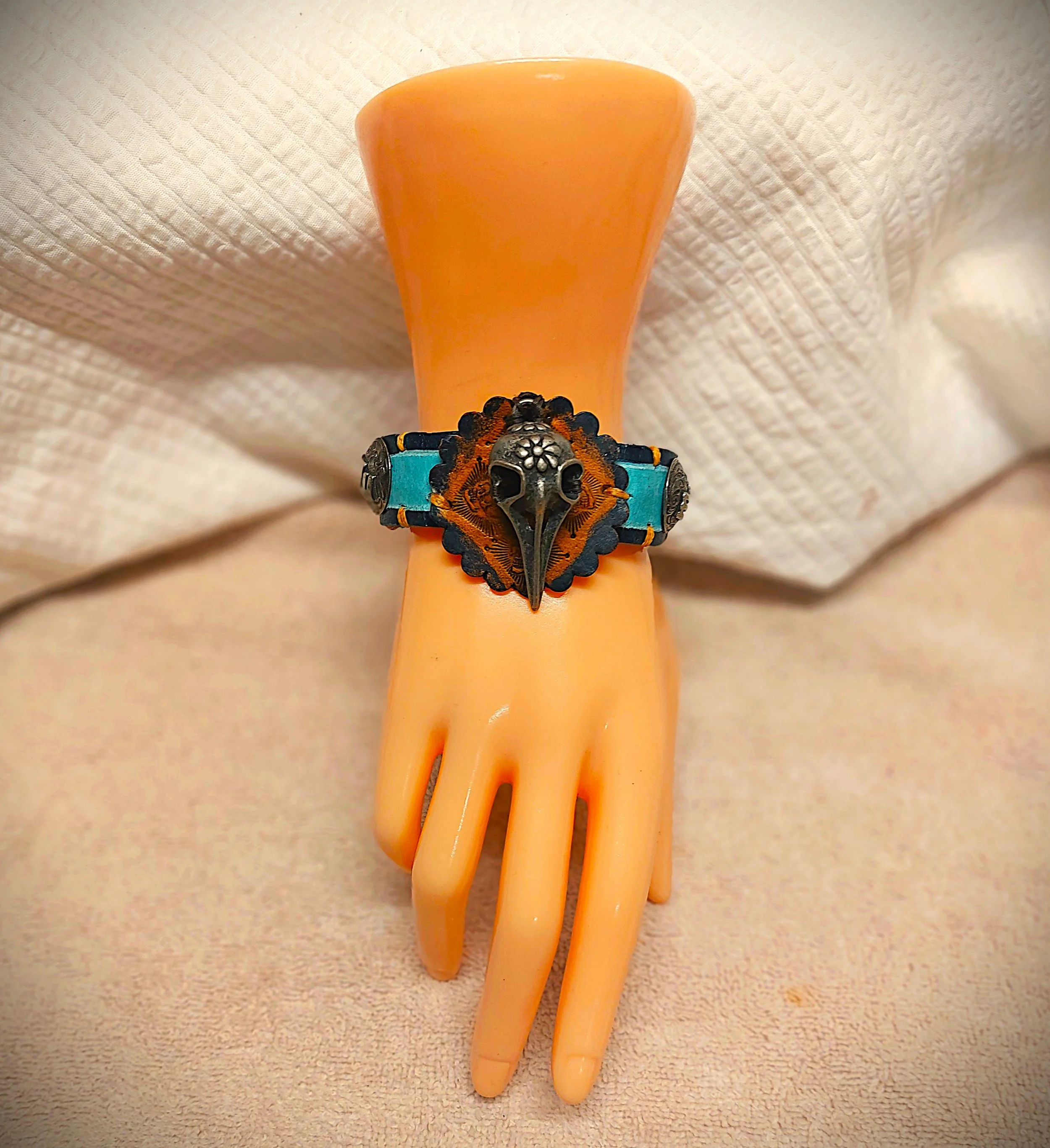 Pewter Bird Skull Perches on Tan Scalloped Concho Centered Light Blue with Navy Narrow Cuff