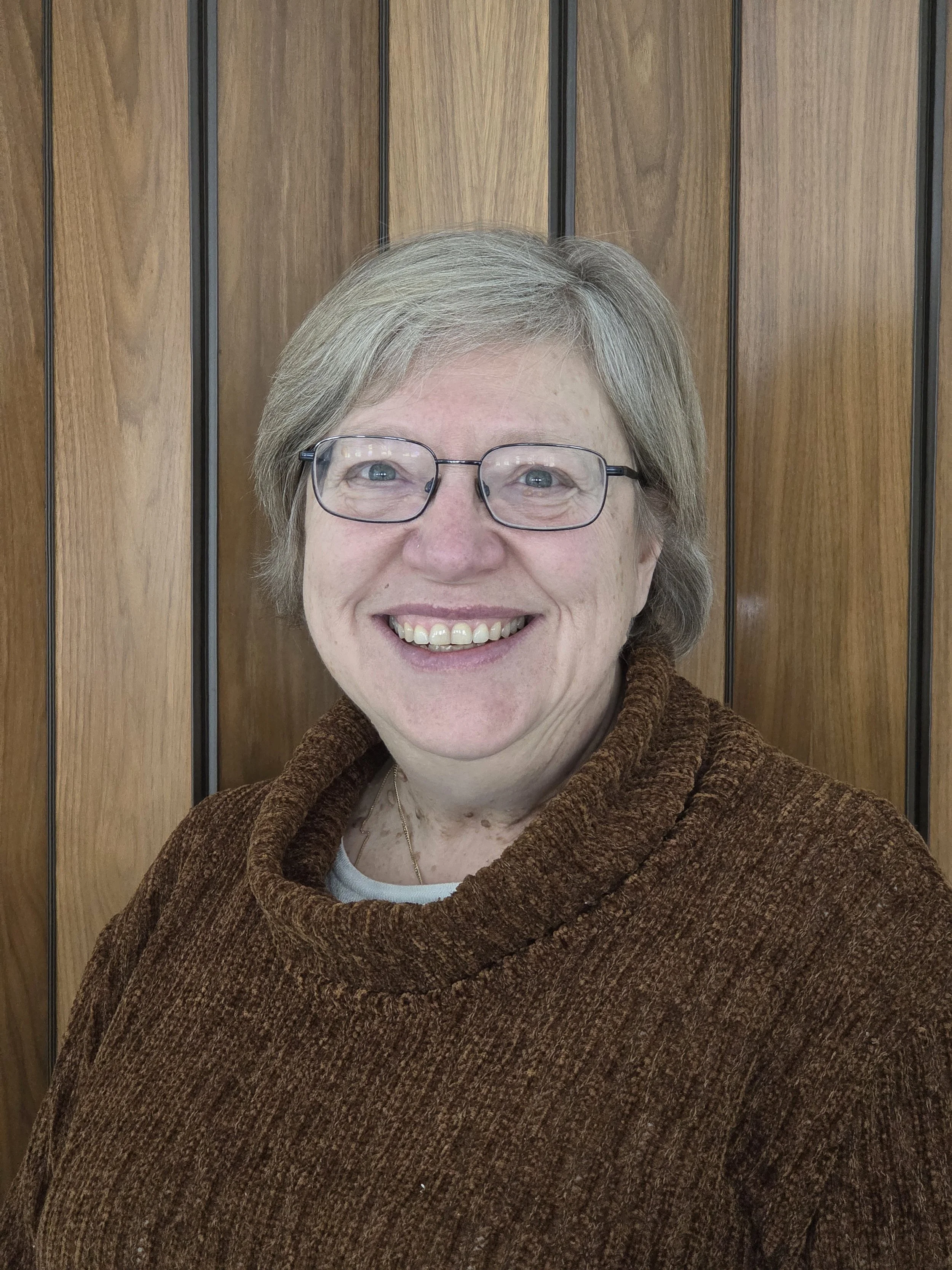 A vintage microphone illuminated by a spotlight against a dark background.